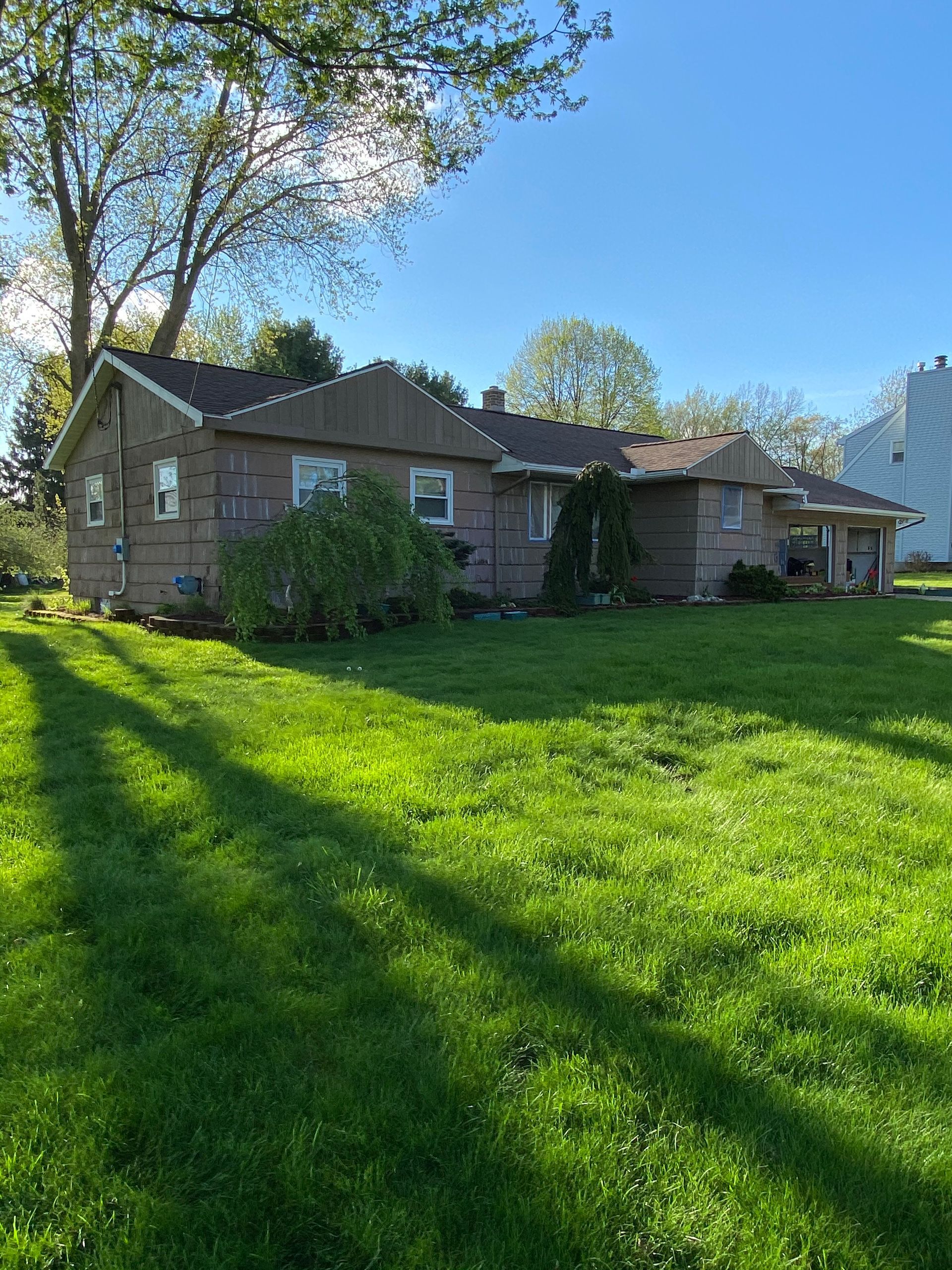 A house with a large lawn in front of it.
