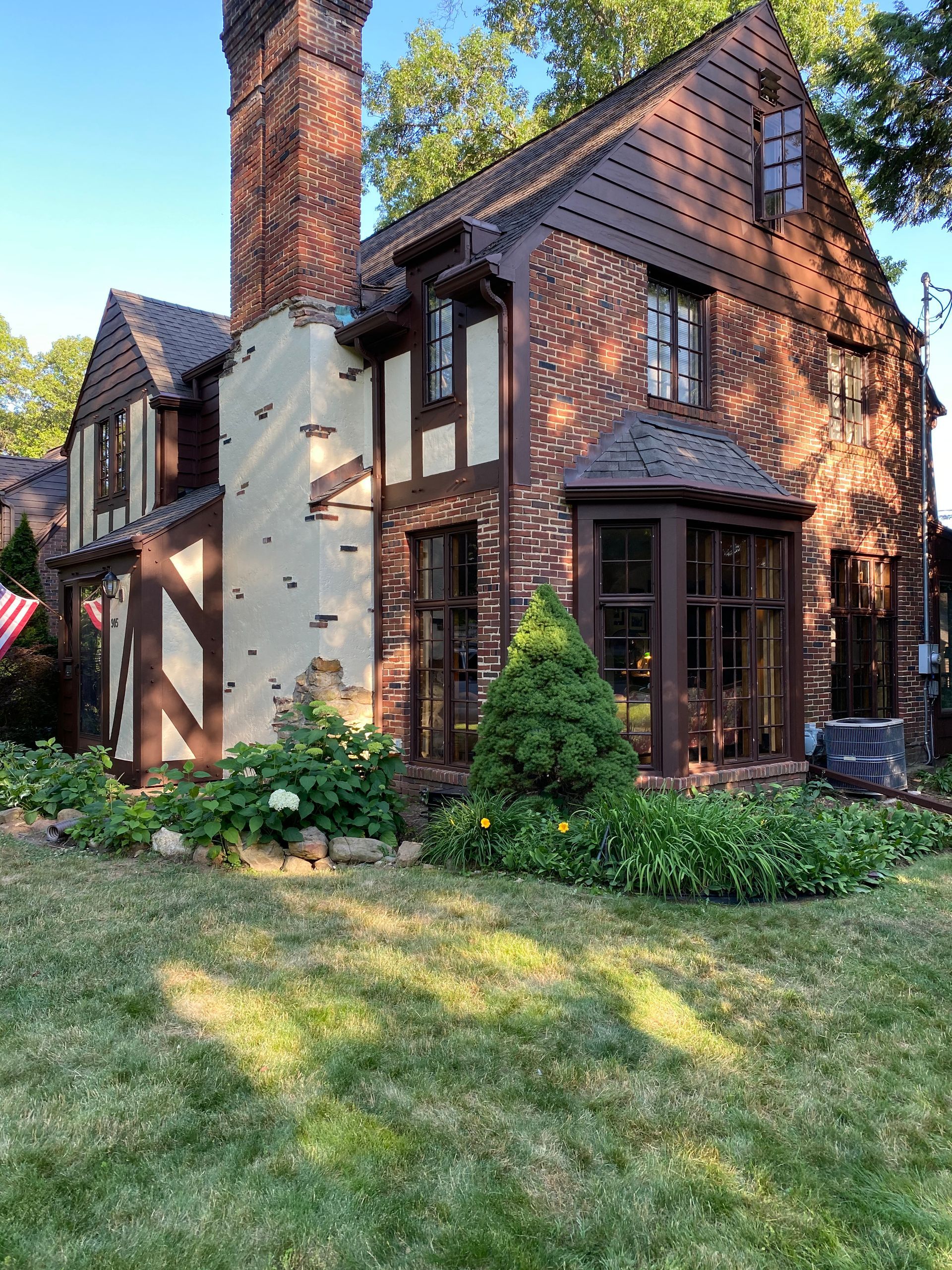 A large brick house with a lot of windows and a chimney.