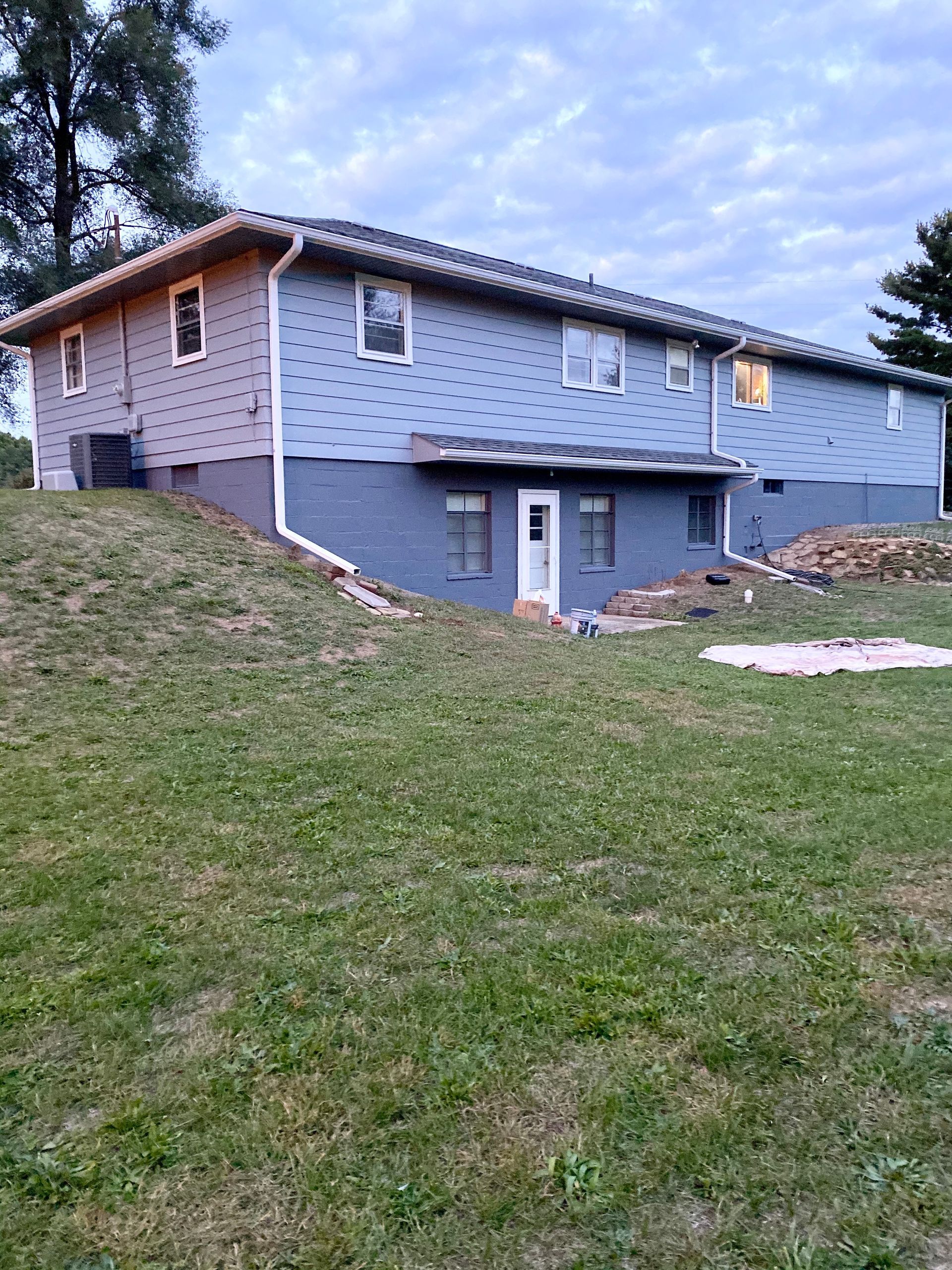 A large house is sitting on top of a grassy hill.
