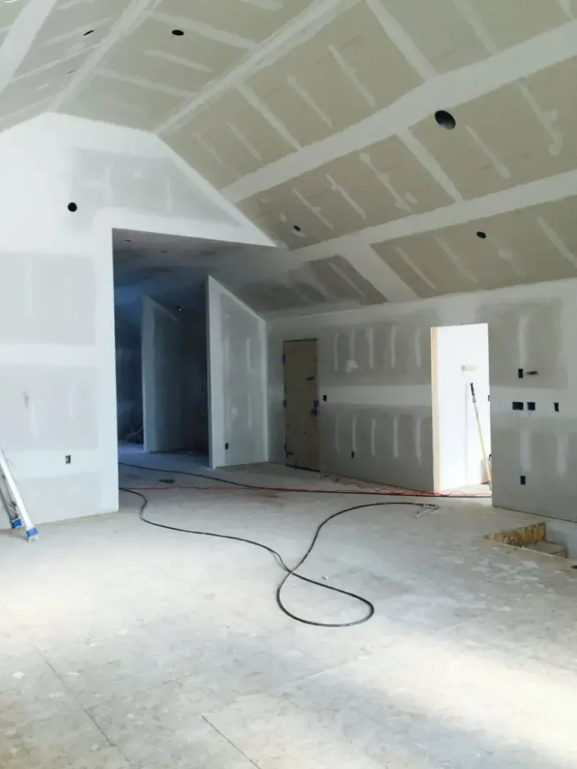 A large empty room with a ladder in the foreground