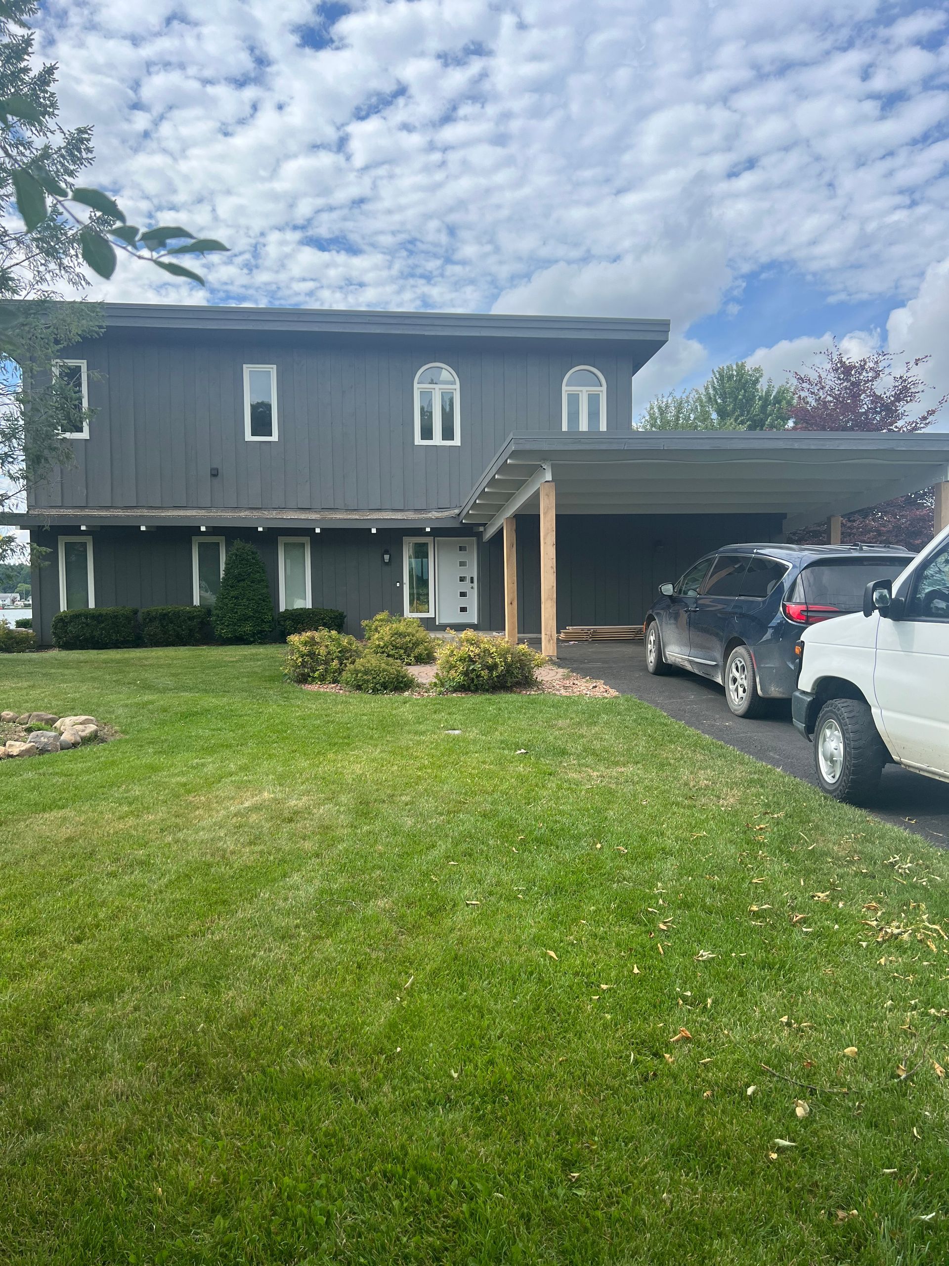 A large house with a carport and a white truck parked in front of it.
