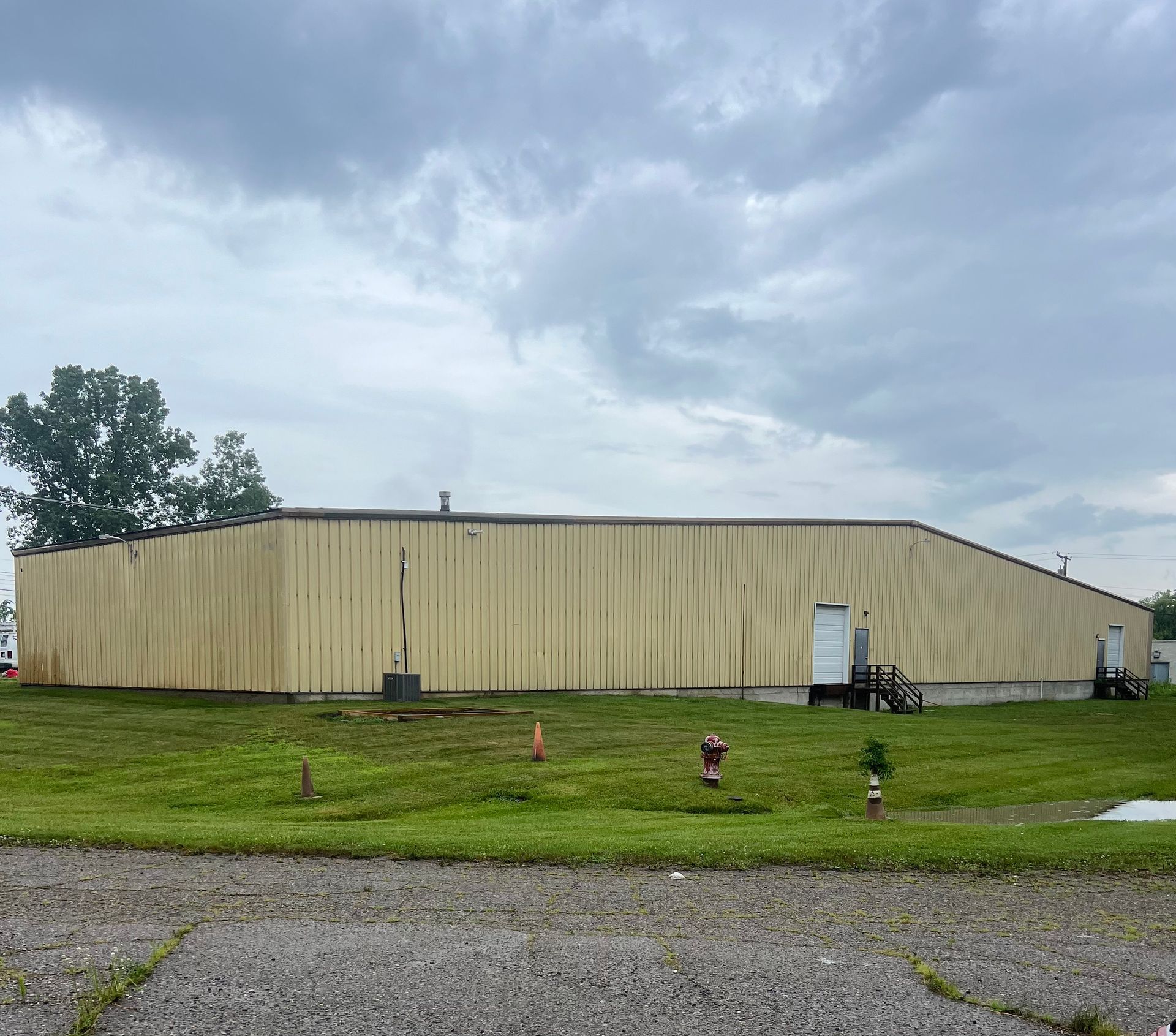 A large building is sitting in the middle of a grassy field.