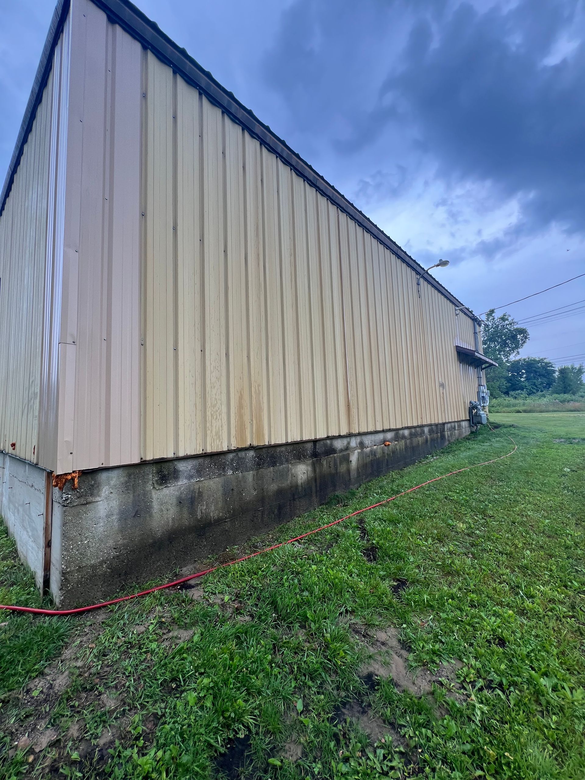 A large building is sitting in the middle of a grassy field.