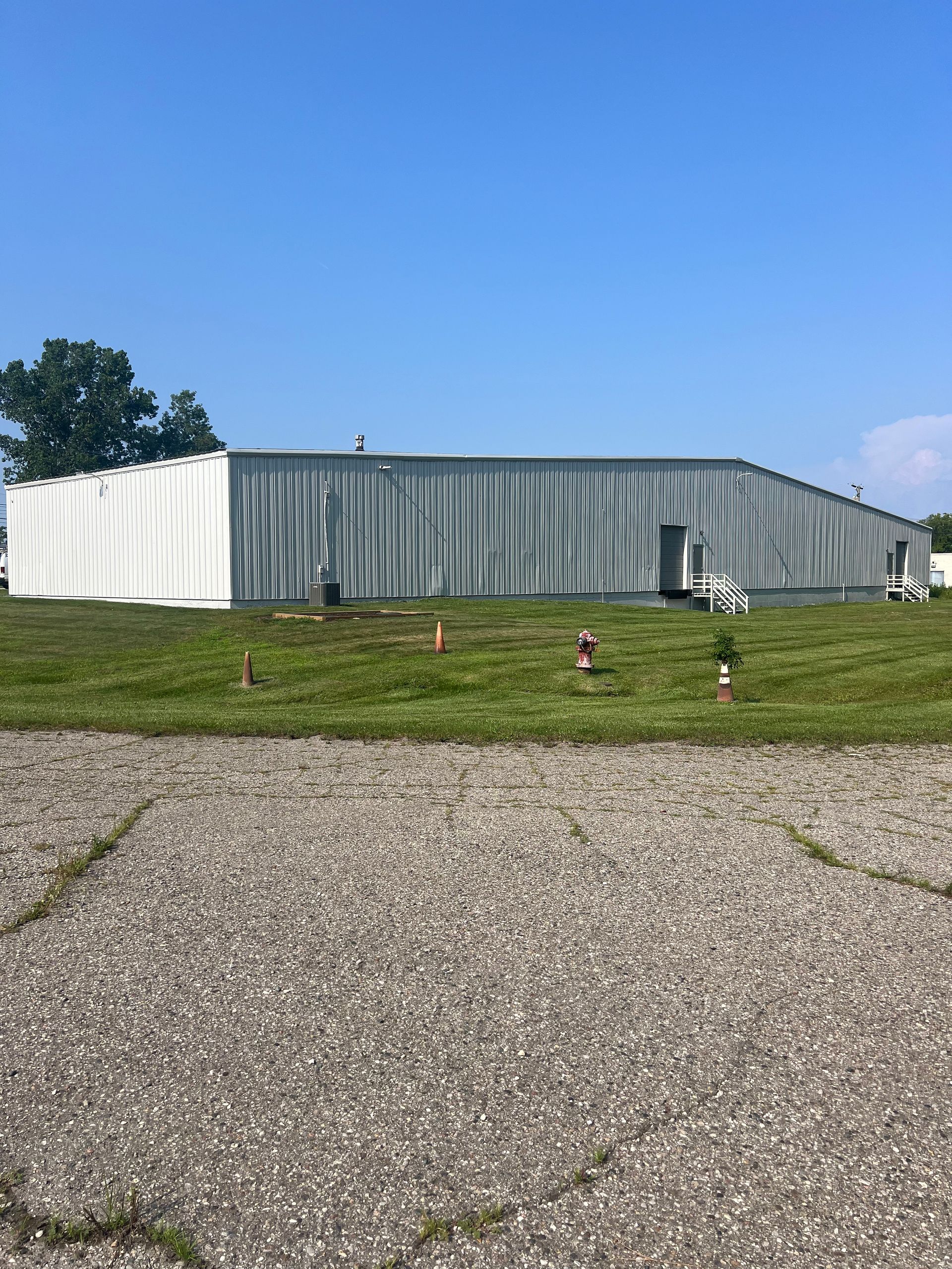 A large building is sitting in the middle of a grassy field.