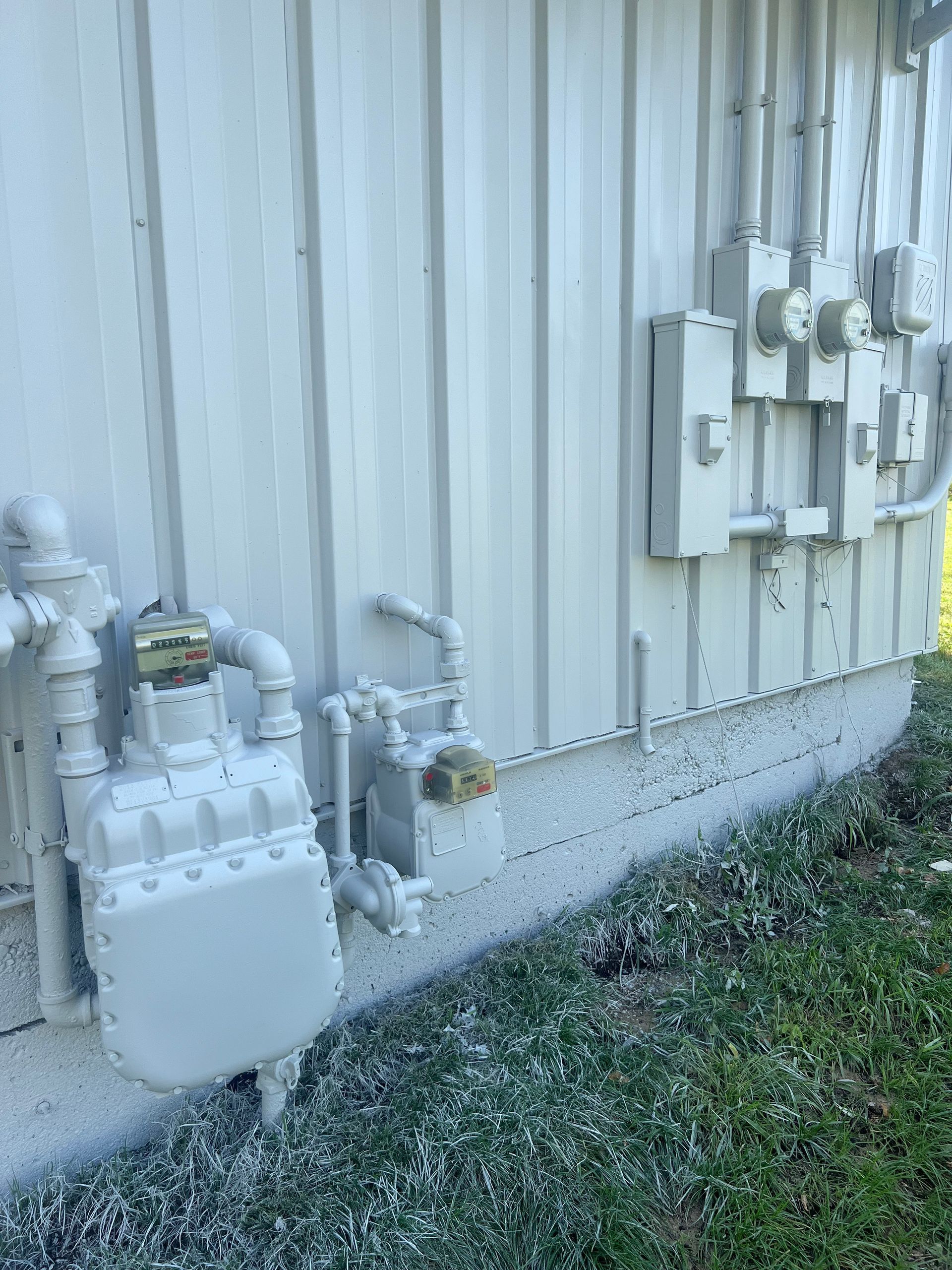 There is a gas meter on the side of a building.