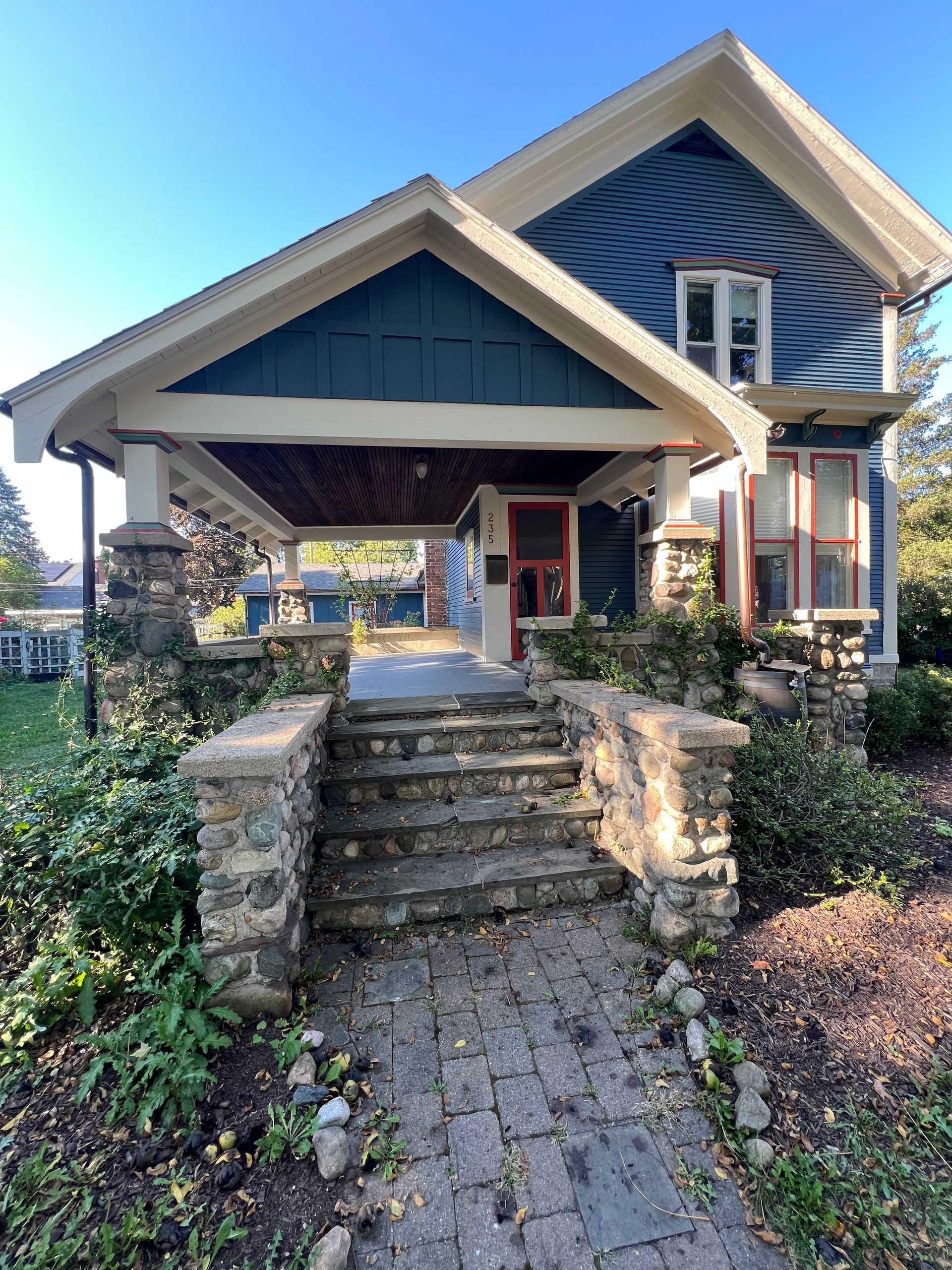 A blue house with a stone walkway leading to it.
