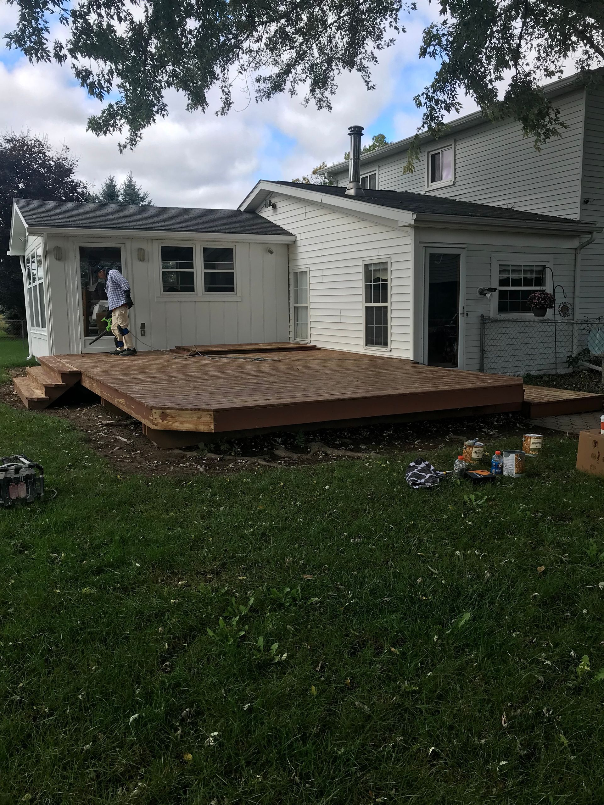 A wooden deck is being built in the backyard of a house.