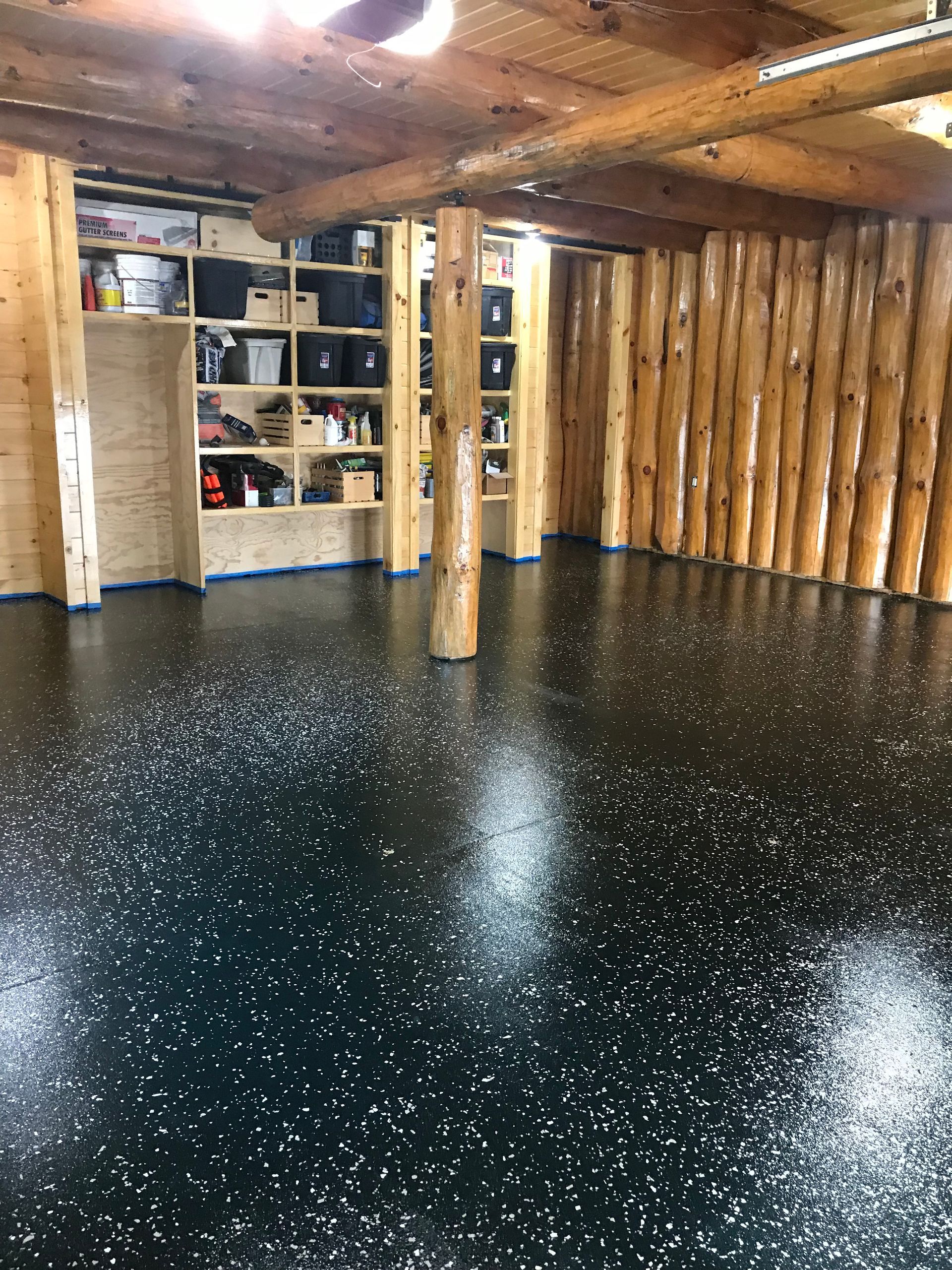 A large room with a black floor and wooden walls.