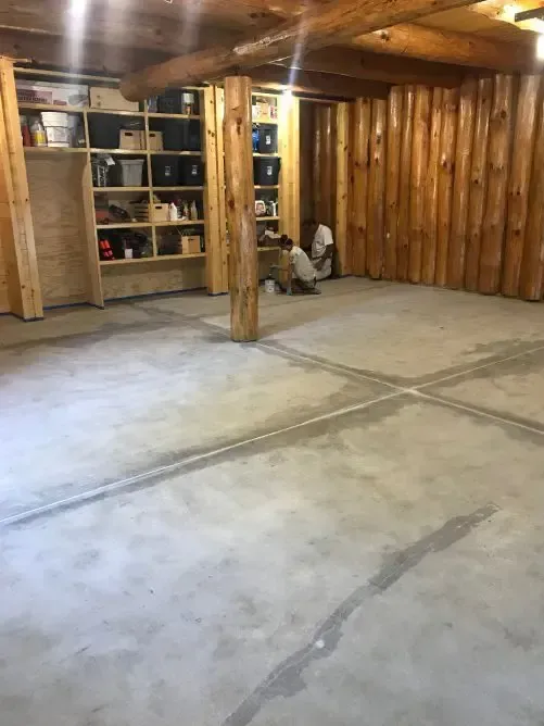 A large empty room with a concrete floor and wooden walls.