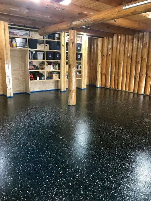 A large room with a black floor and wooden walls.