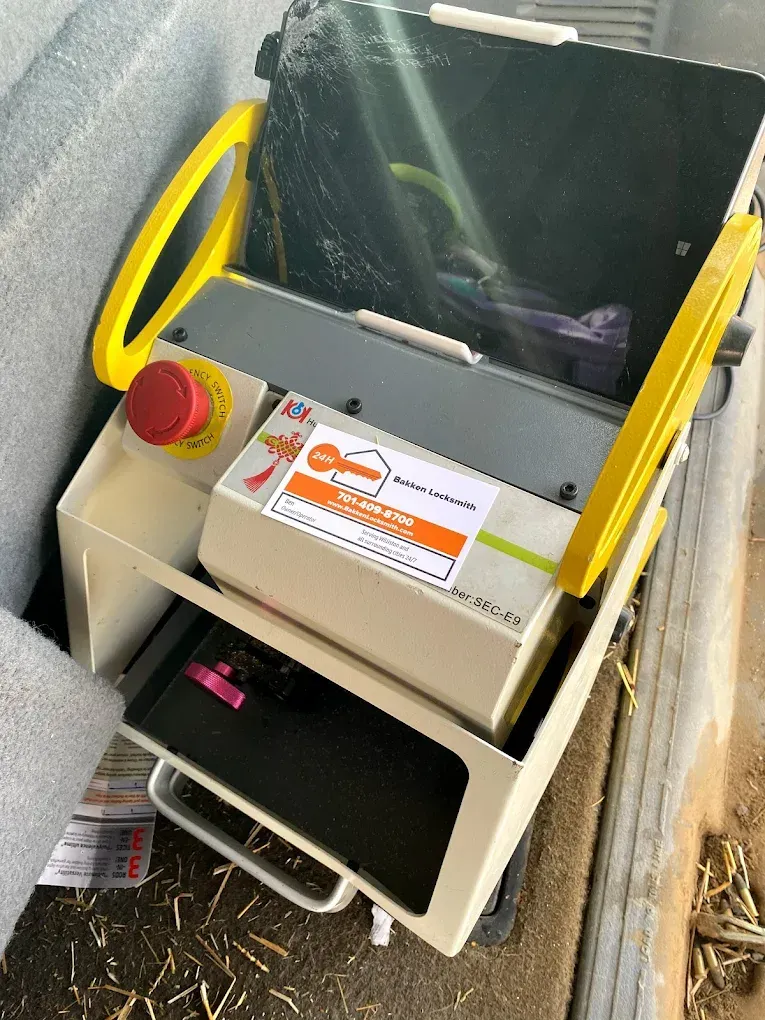 Tan and yellow portable cutting machine with red emergency stop button, inside a case.