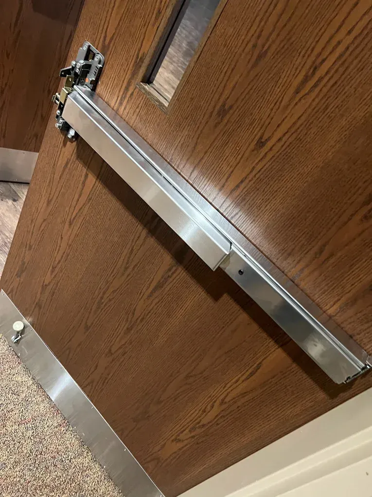 Brown door with an aluminum door closer and stainless steel trim.