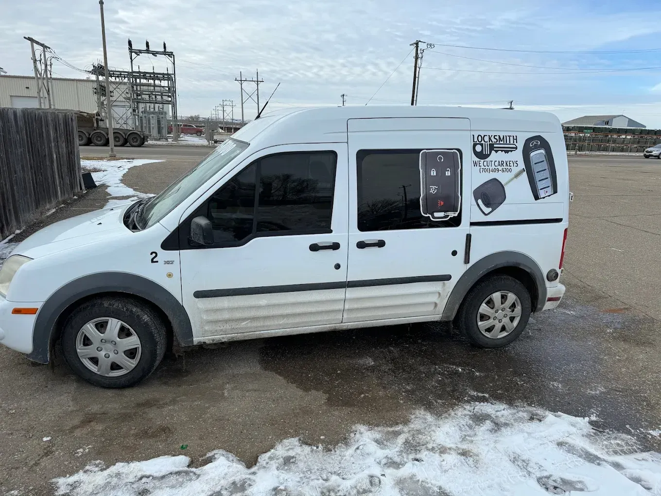 White van with company logo parked on a snowy lot.