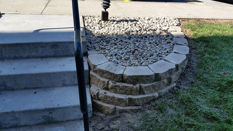 A stone wall is sitting next to a set of stairs.