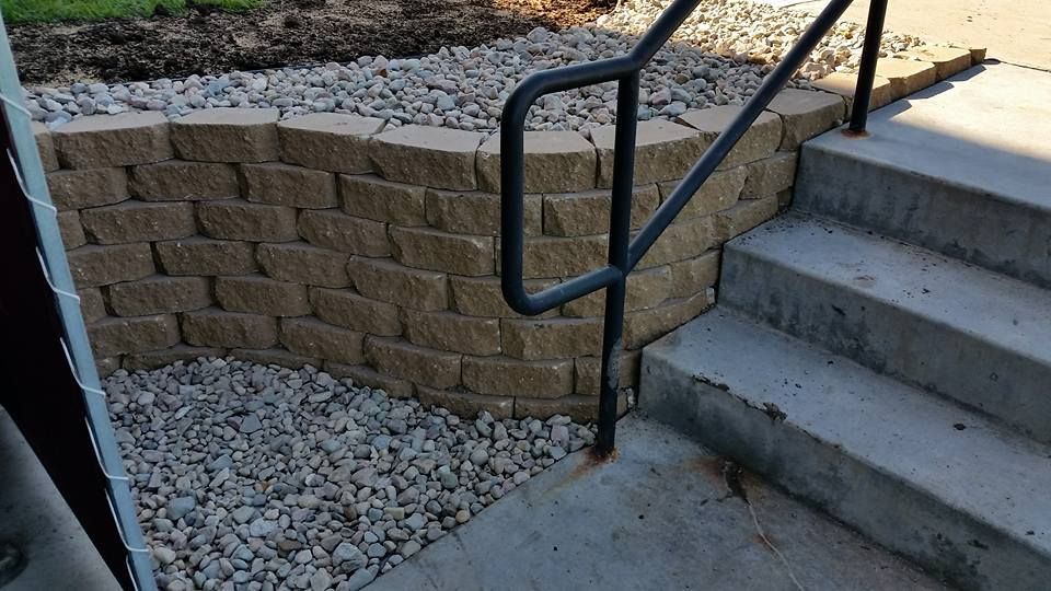 A staircase with a brick wall and a metal railing