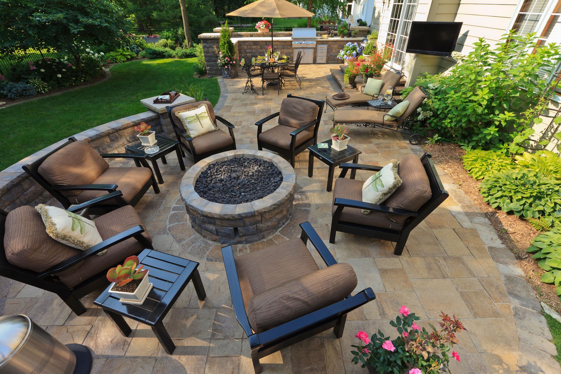 A patio with a fire pit surrounded by chairs and tables