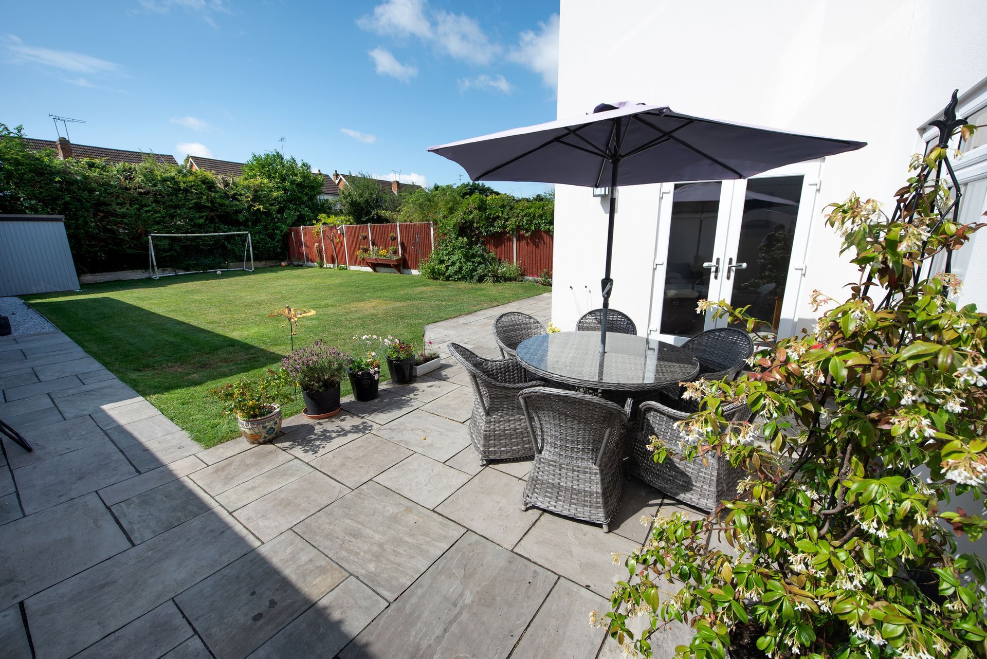 A patio with a table and chairs and an umbrella A patio with a table and chairs and an umbrella