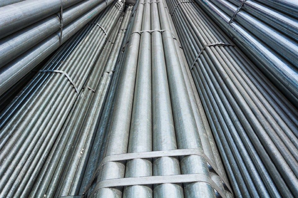A bunch of metal pipes are stacked on top of each other.