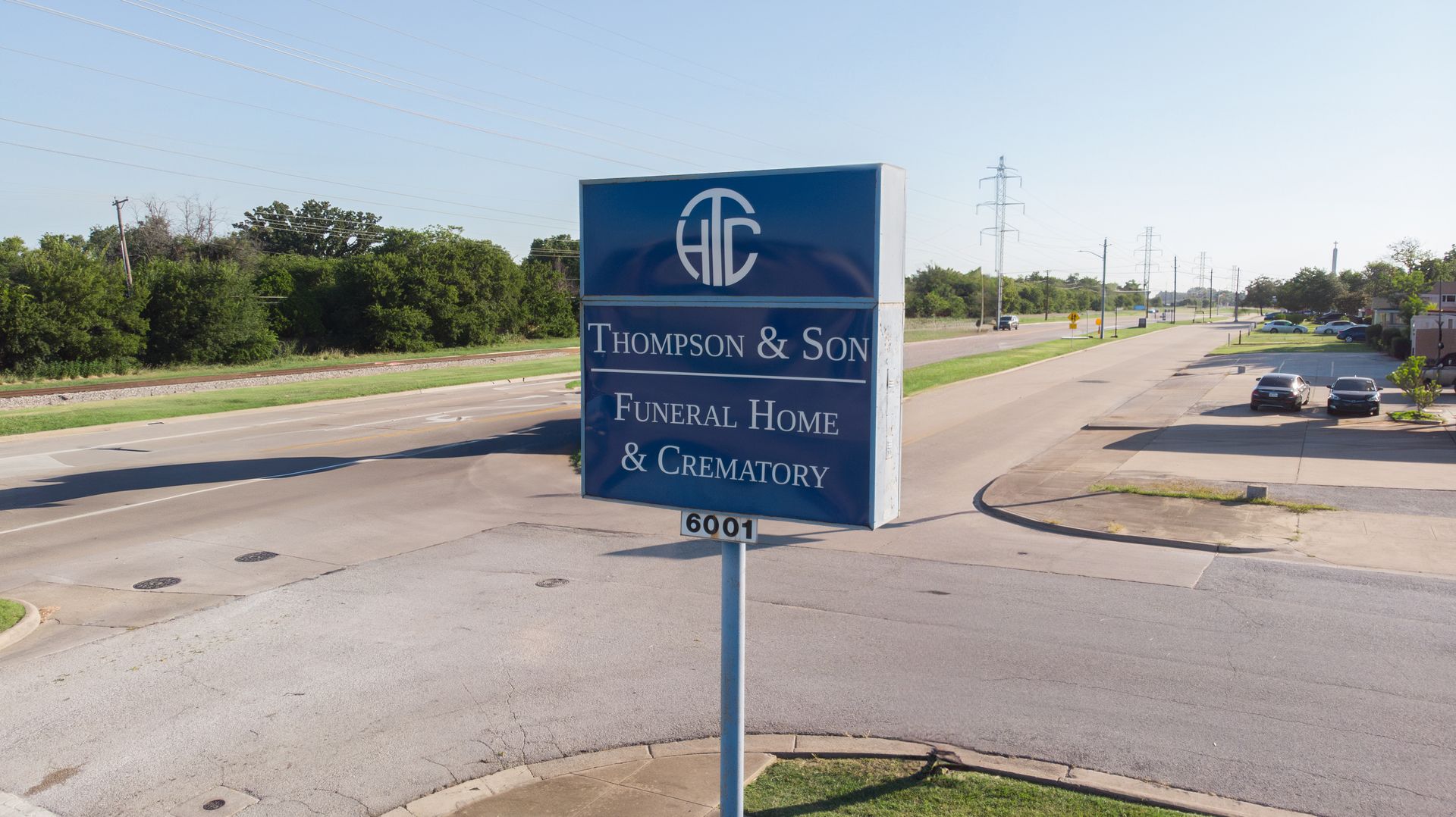 Blue roadside sign for a funeral home and chapel on a sunny street