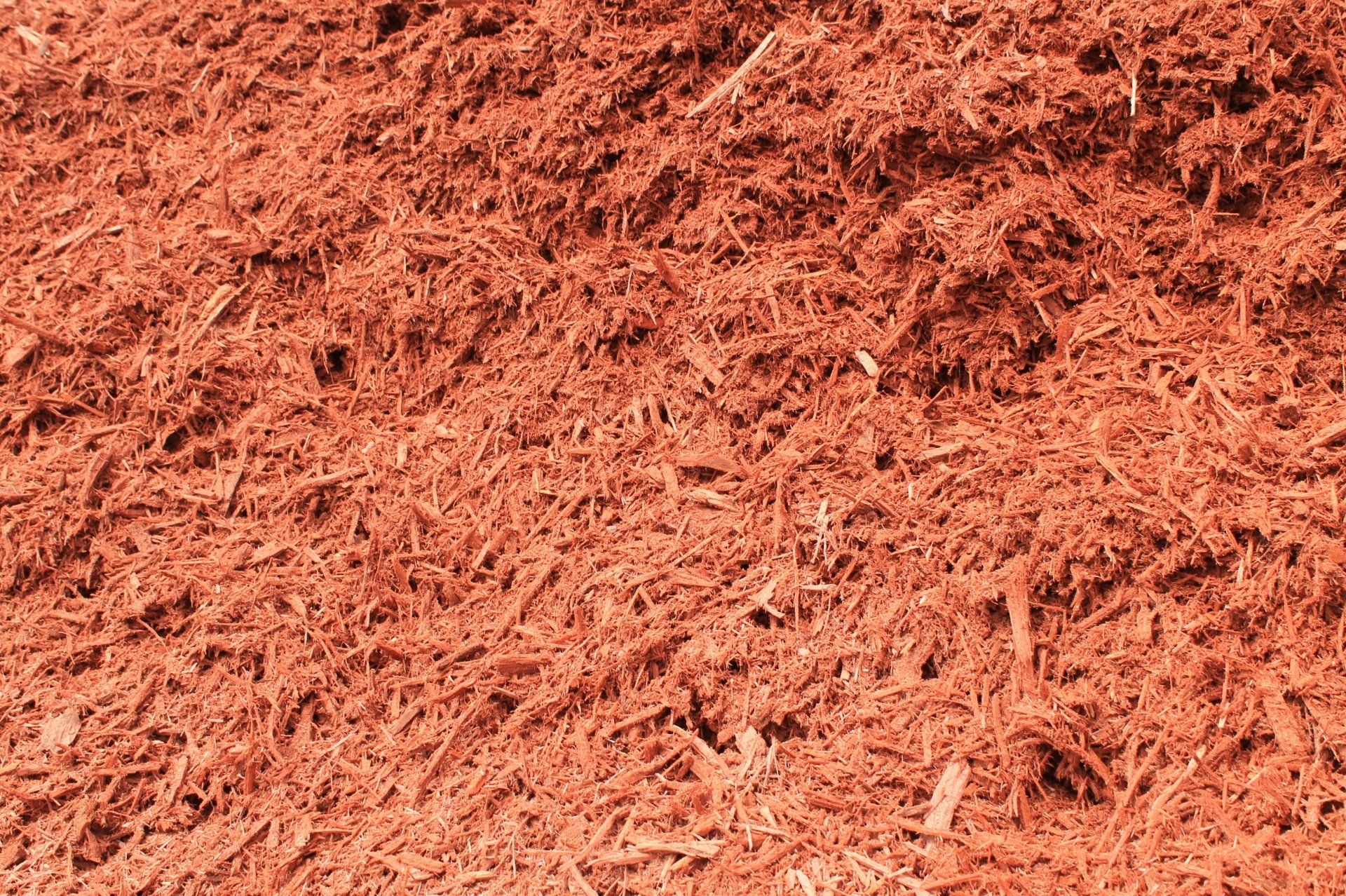 Reddish-brown shredded wood mulch.