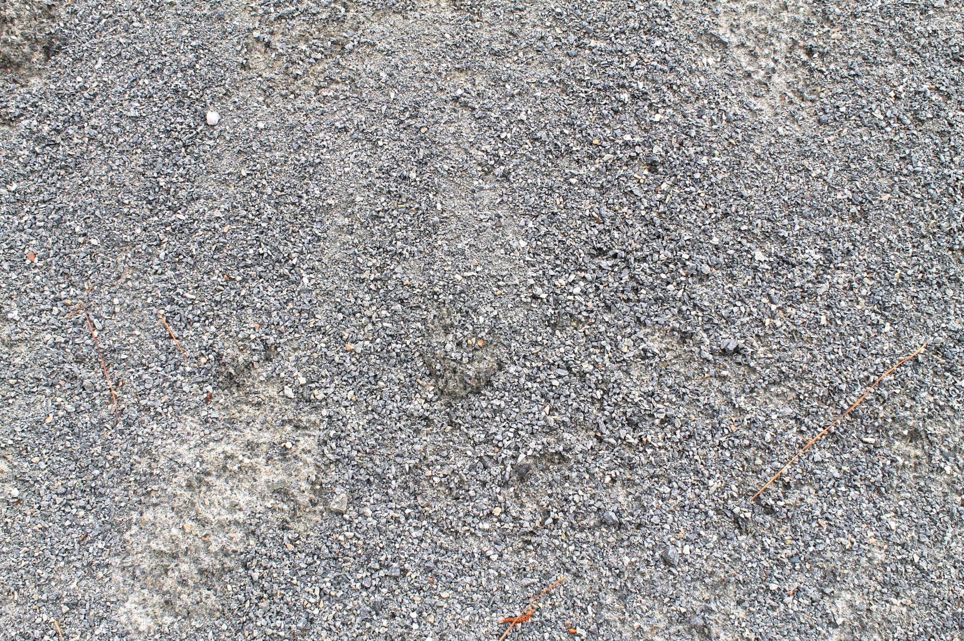 Close-up of a gravel surface, primarily gray with small variations in color and texture.