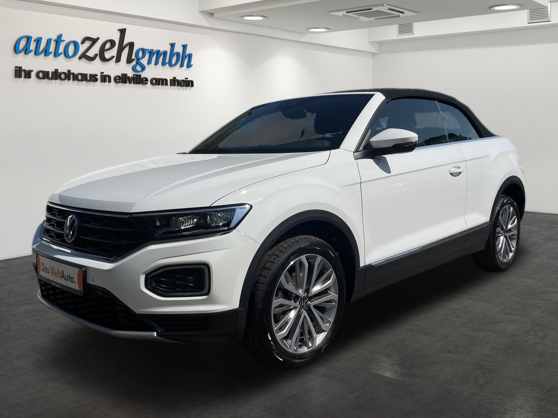 White Volkswagen SUV in a showroom with a black roof and silver wheels