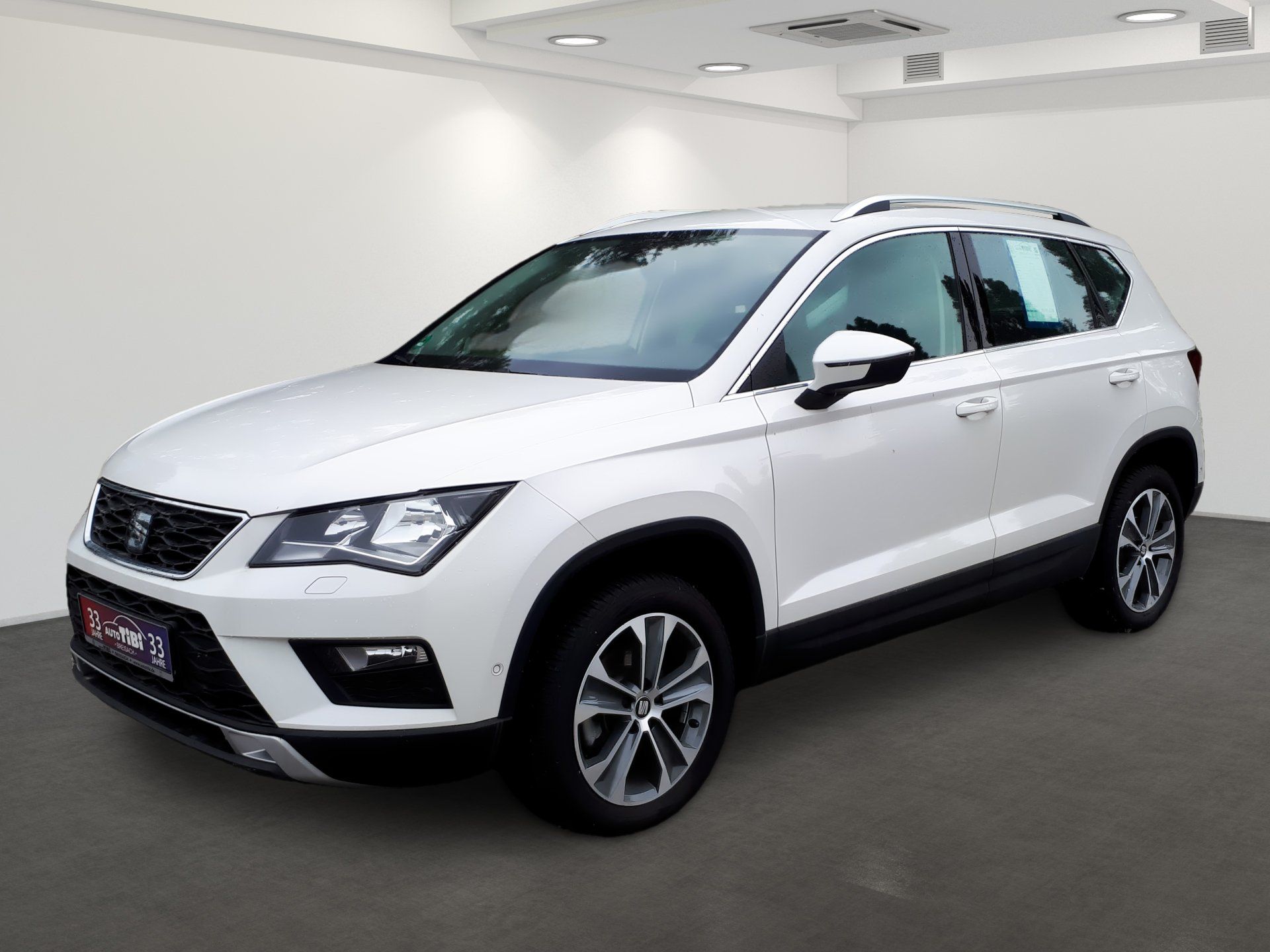 Biele SUV vystavené v showroome, pohľad z ľavého uhla spredu