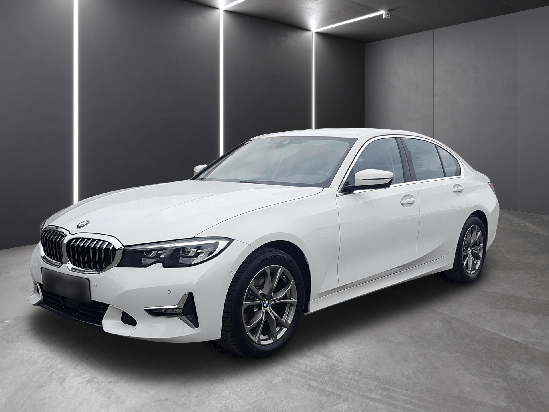 White BMW sedan parked in a gray studio with vertical light strips