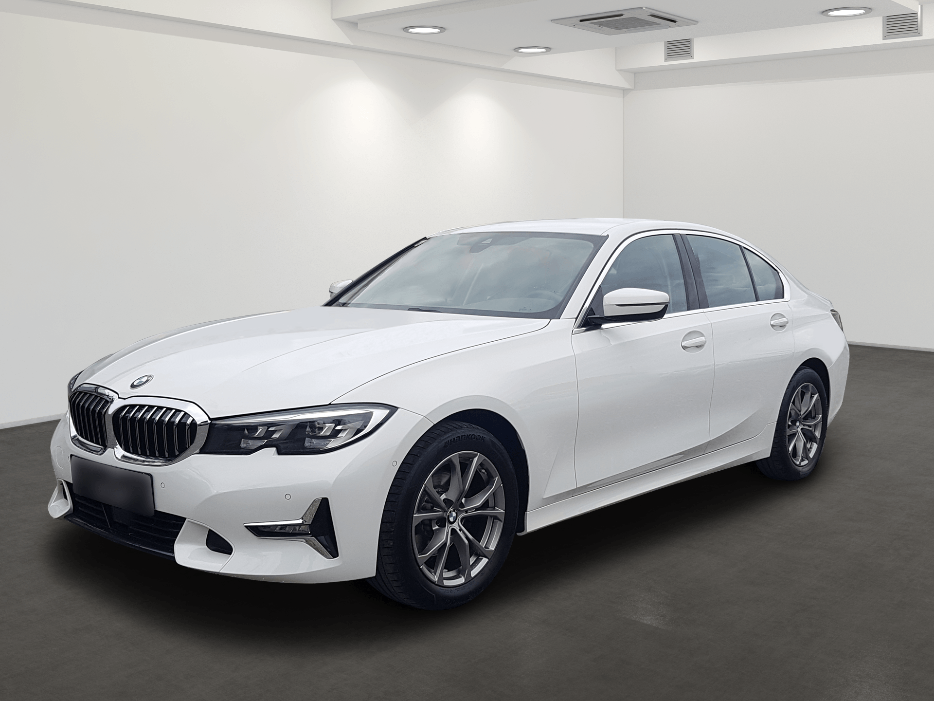 White BMW sedan in a clean studio showroom, angled front-left view