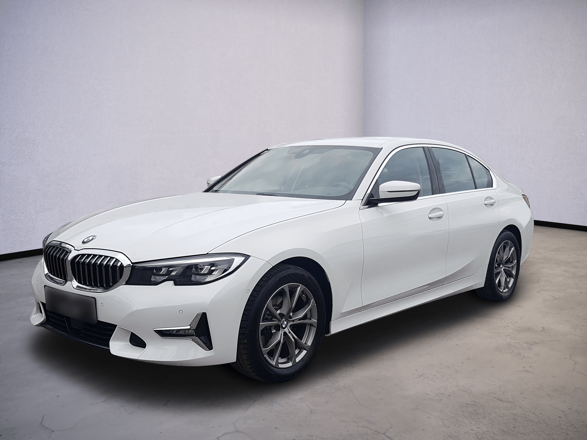 White BMW sedan in a studio, front three-quarter view on a gray floor.