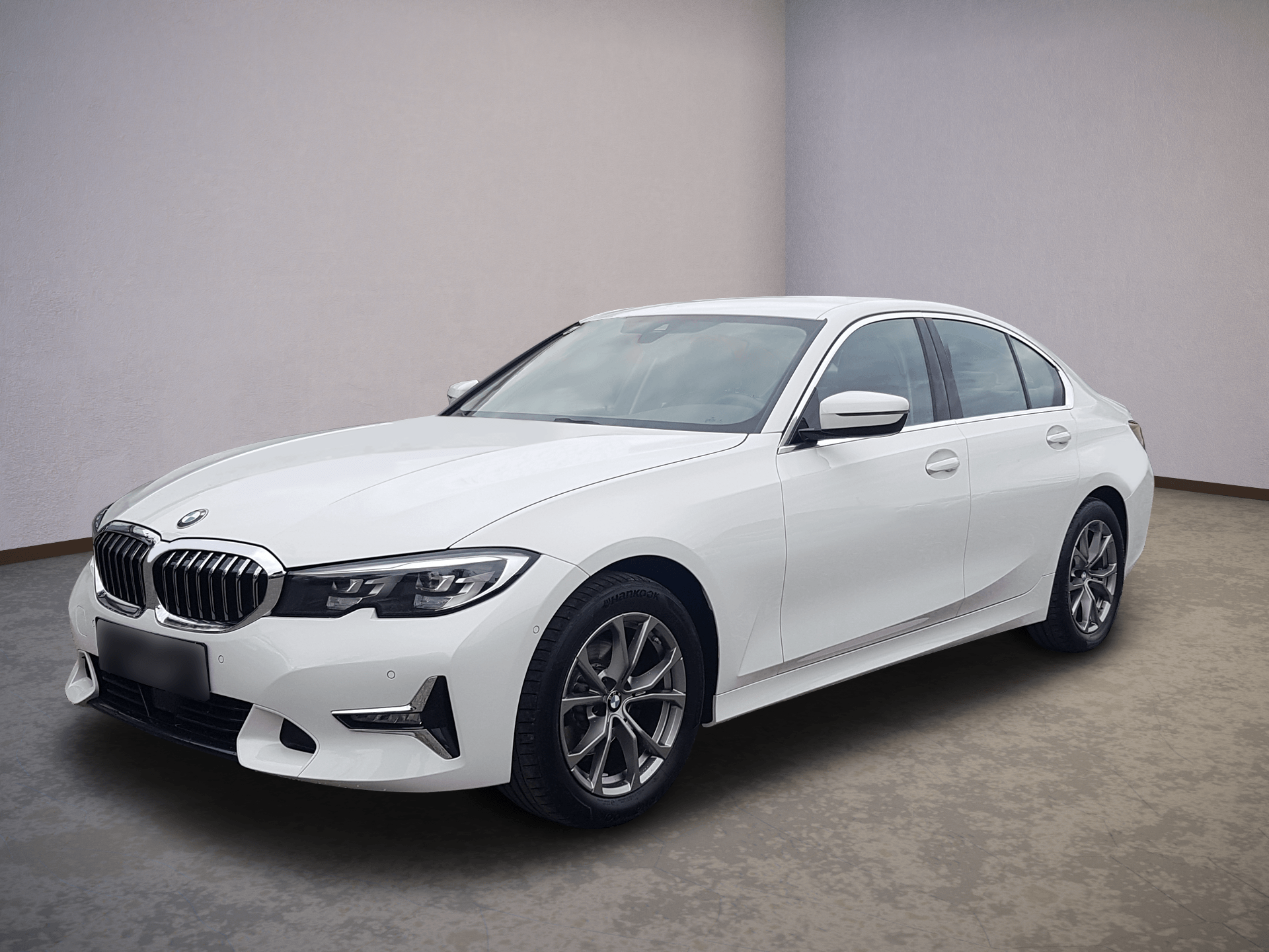 White BMW sedan parked in a studio, front-left angle