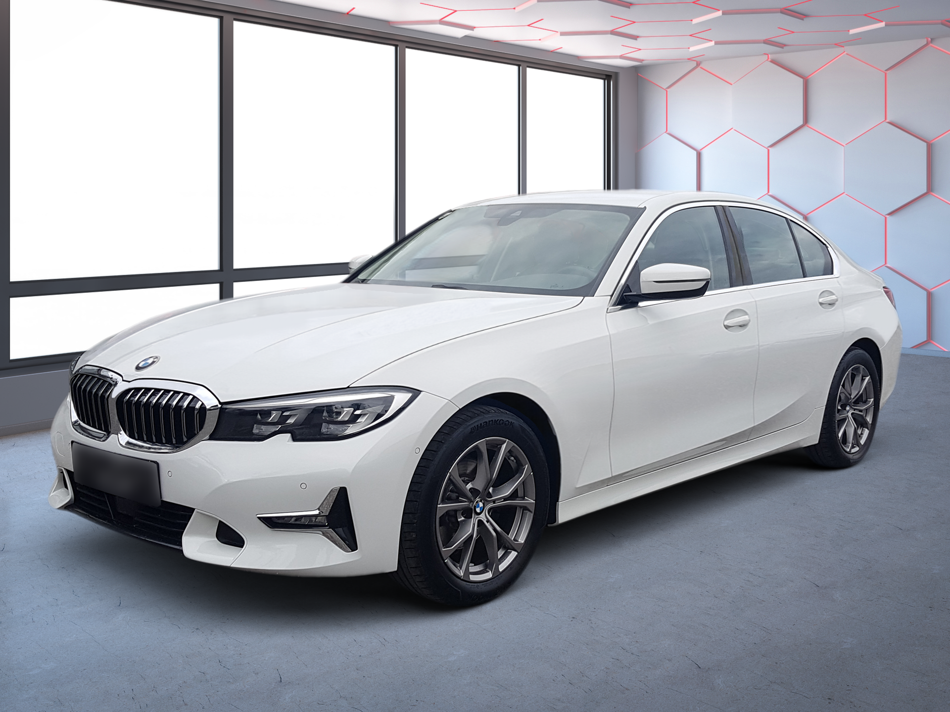 White BMW sedan in a studio setting with large windows and a gray floor