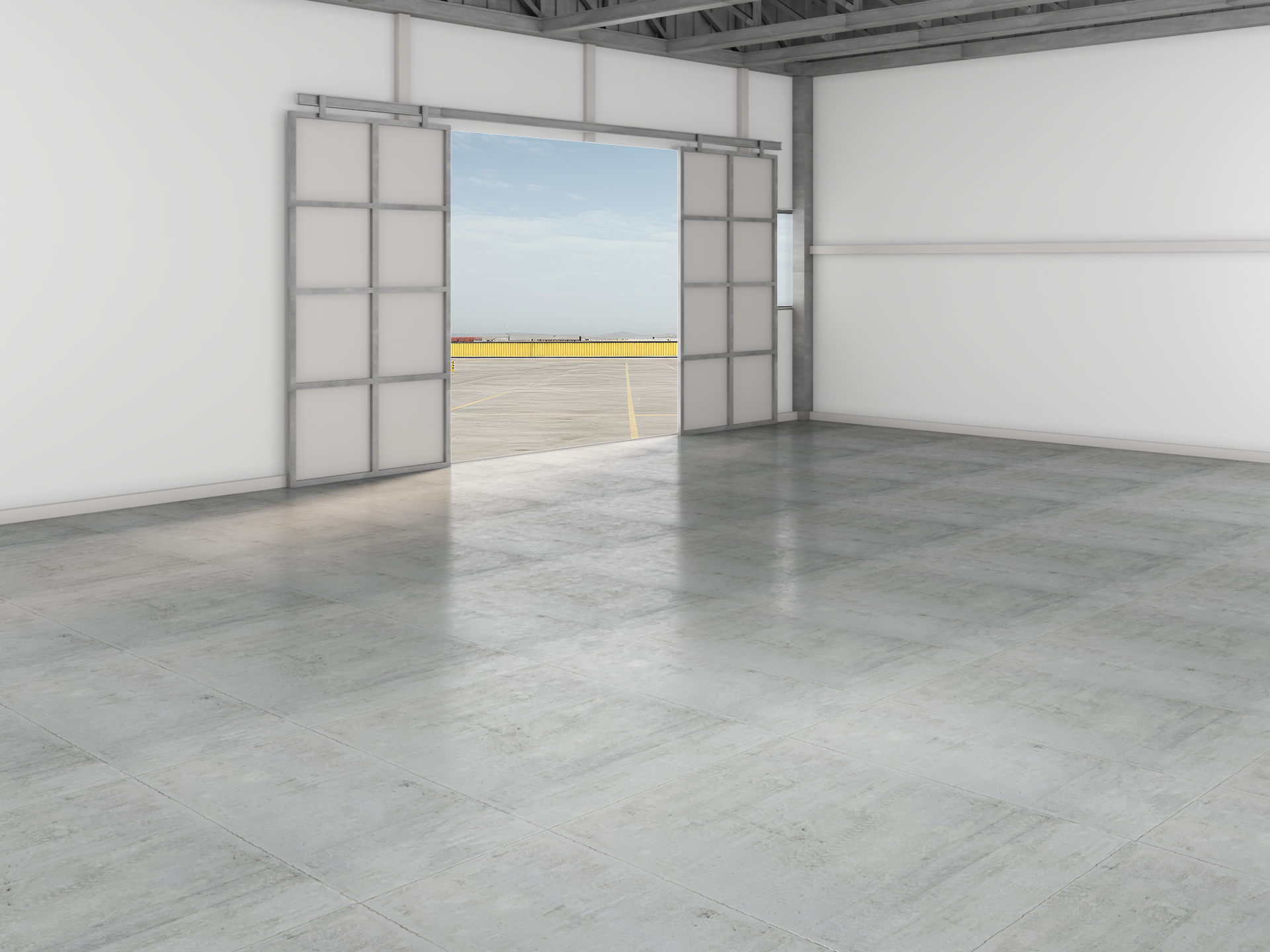 Empty industrial showroom with open roll-up doors and a concrete floor