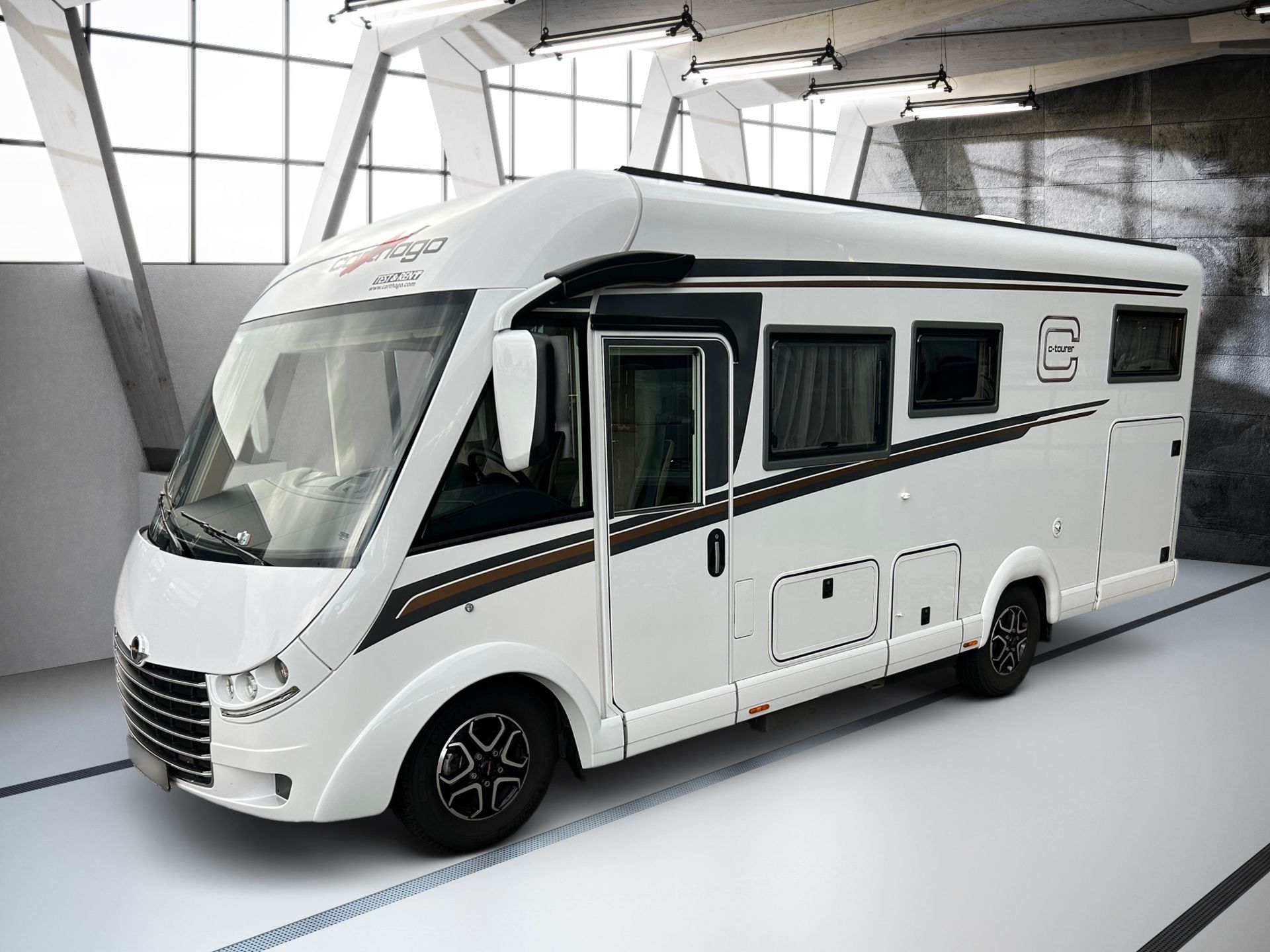 Biely obytný automobil zaparkovaný v interiéri svetlej predajne, pohľad z ľavej prednej strany.