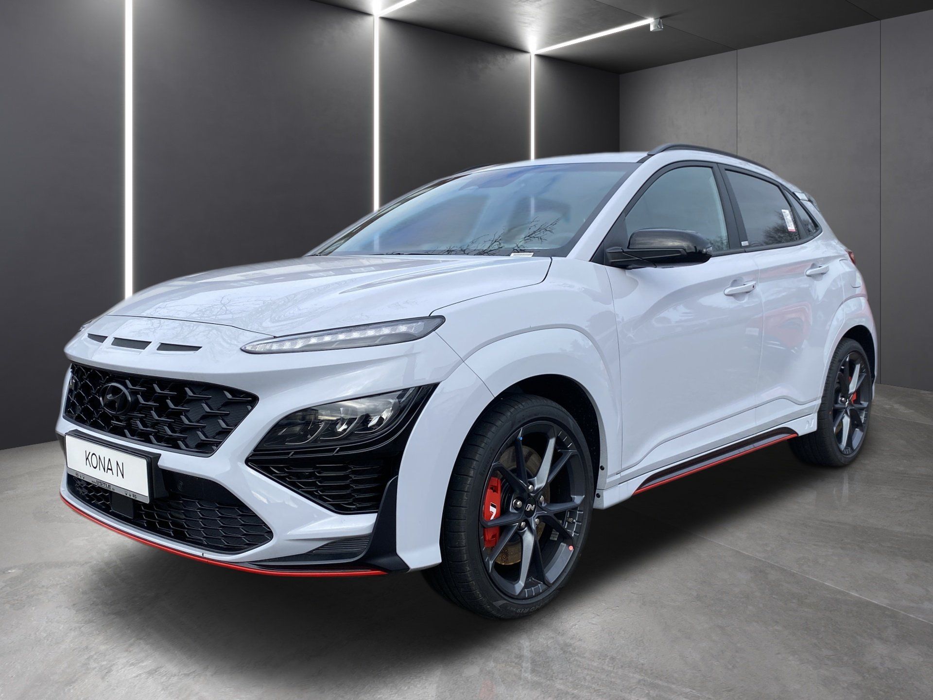 White sporty SUV with black accents and red trim, shown in a studio setting.
