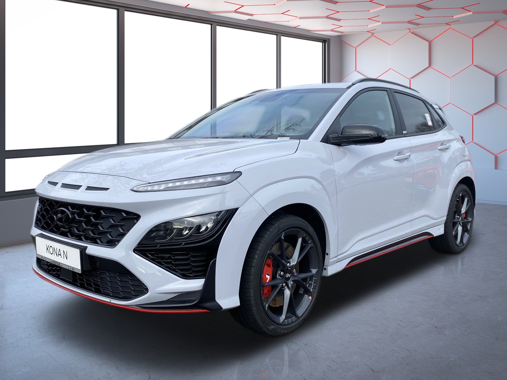 Silver SUV in a showroom with black accents and red trim, angled front view