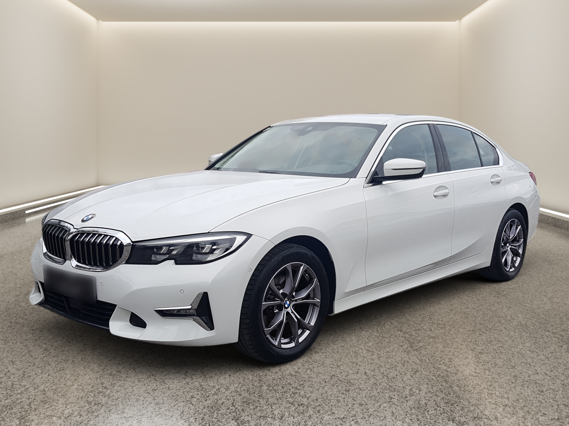White BMW sedan parked in a minimalist beige showroom, viewed from the front-left side.