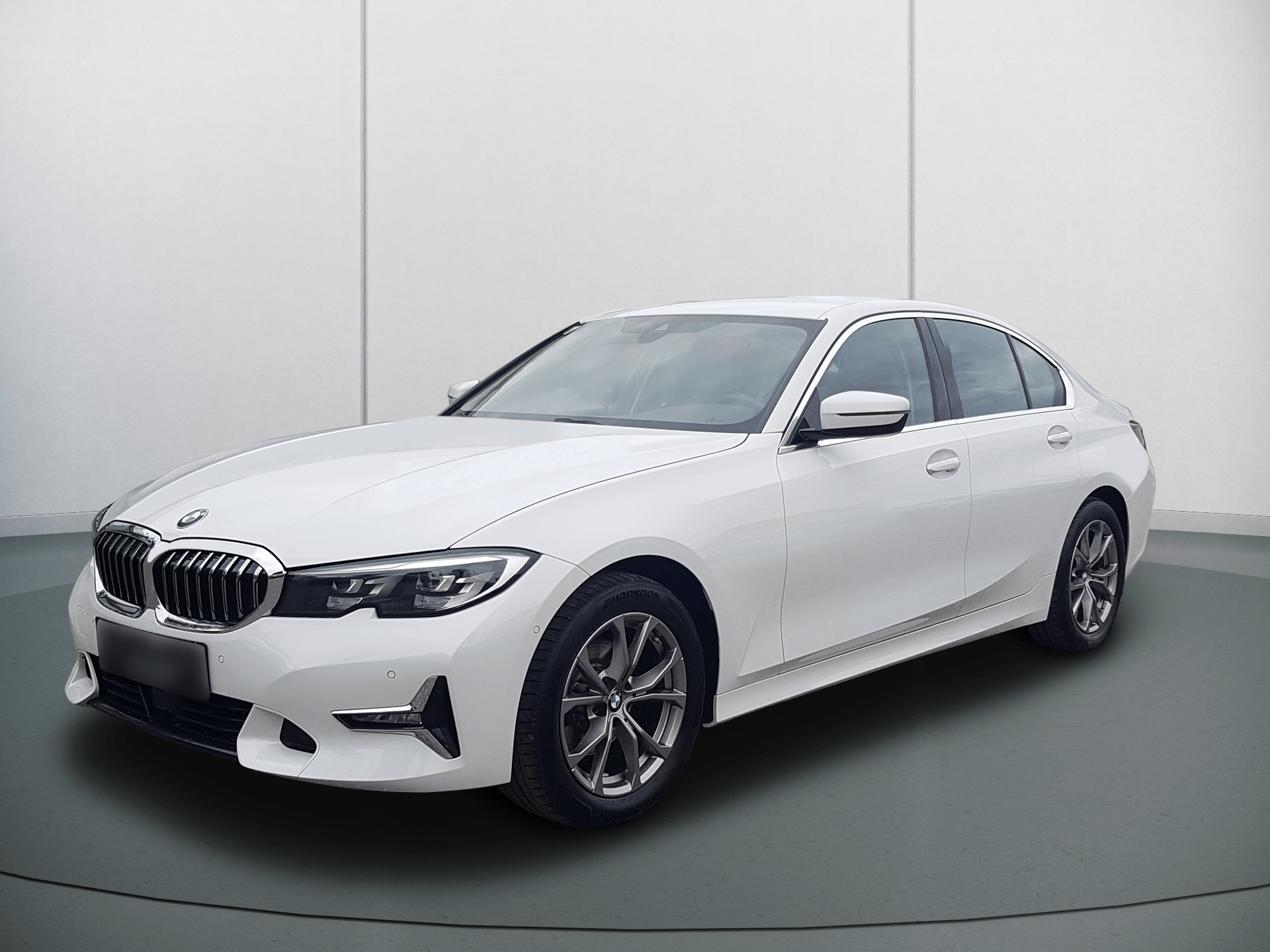 White BMW sedan in a studio with a plain gray background