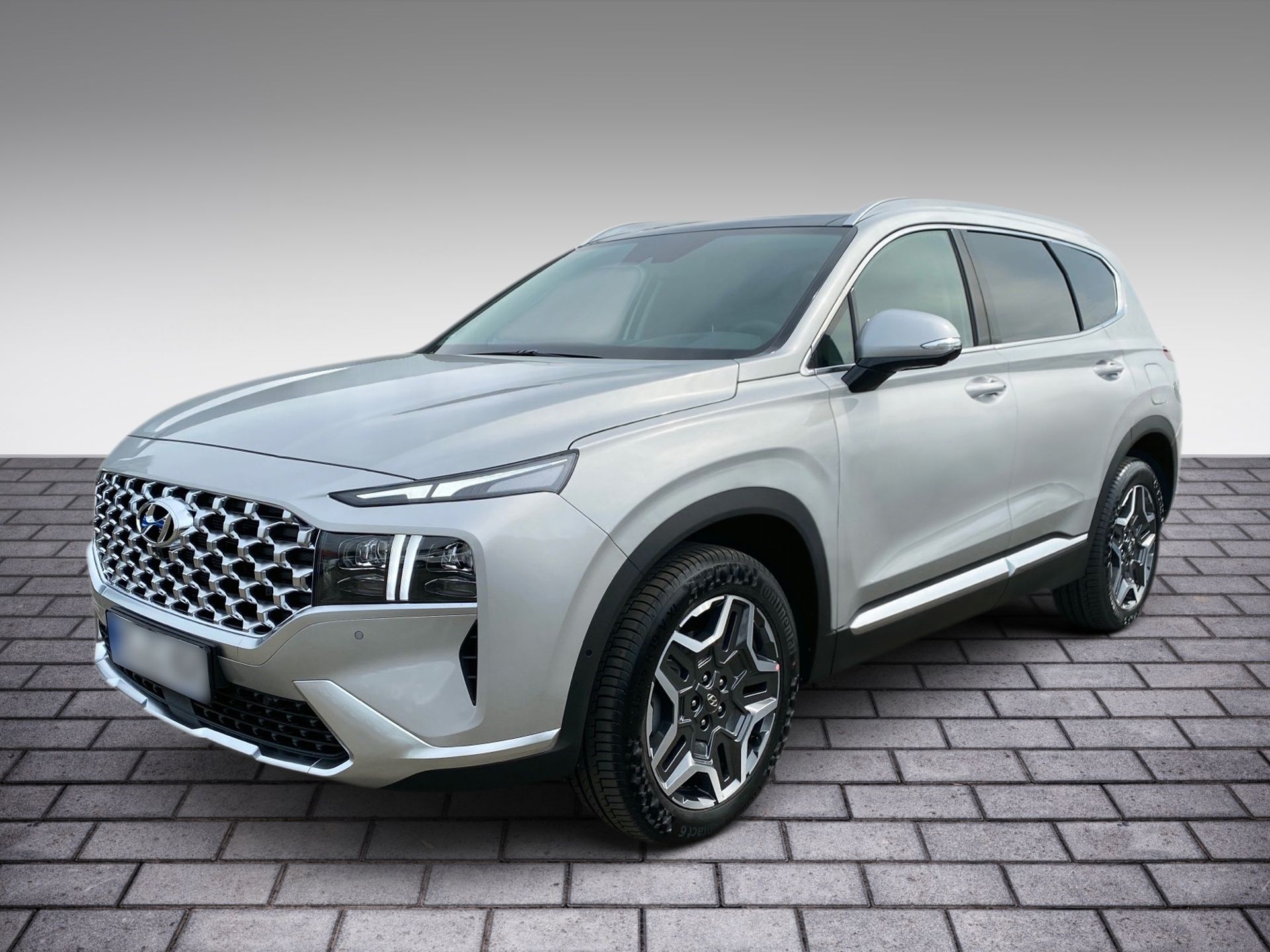 Strieborné SUV zaparkované na tehlovom povrchu, pohľad zľava spredu
