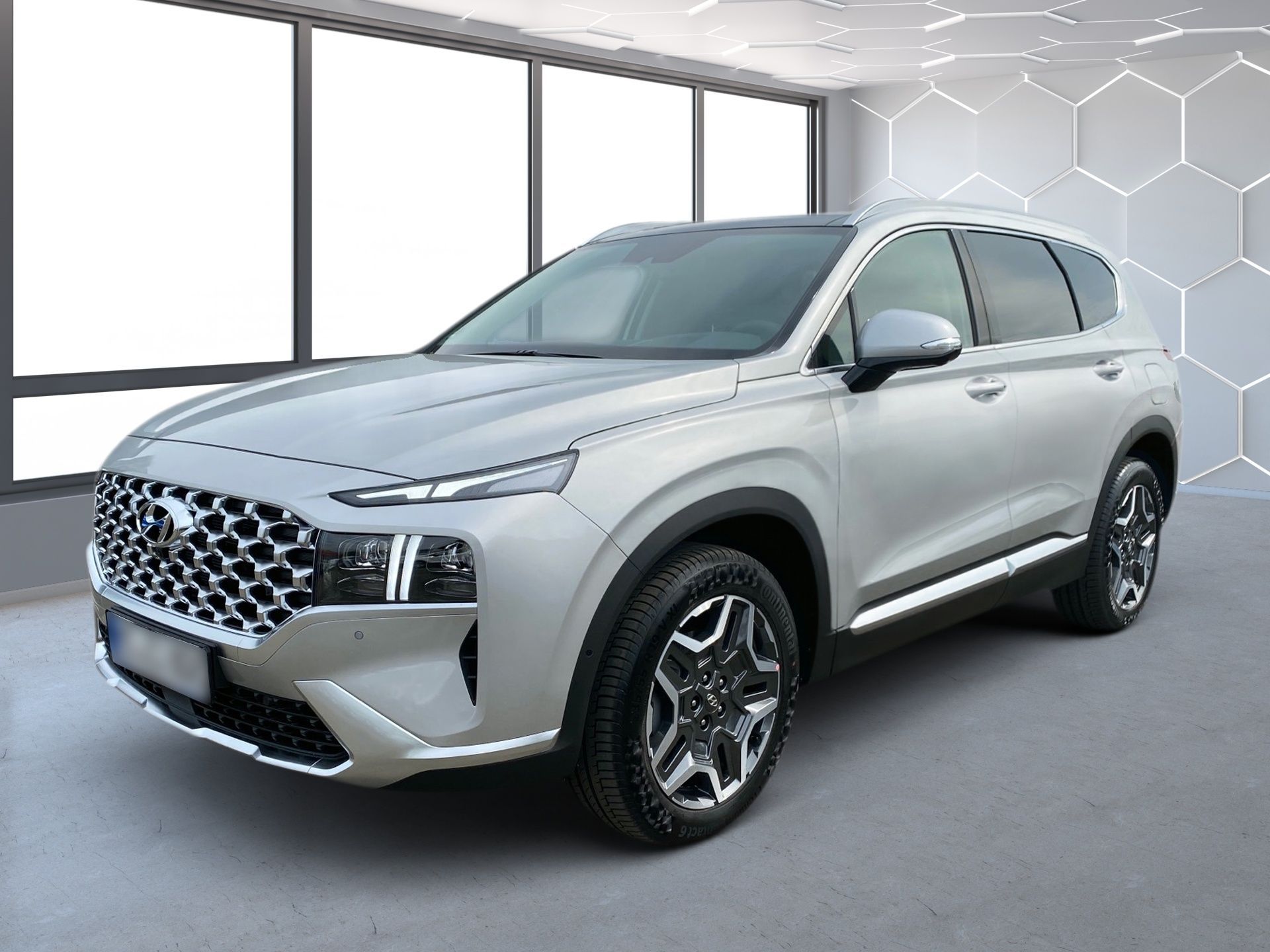 Strieborné SUV v presvetlenej predajni, zobrazené vľavo spredu so šesťuholníkovou stenou v pozadí.