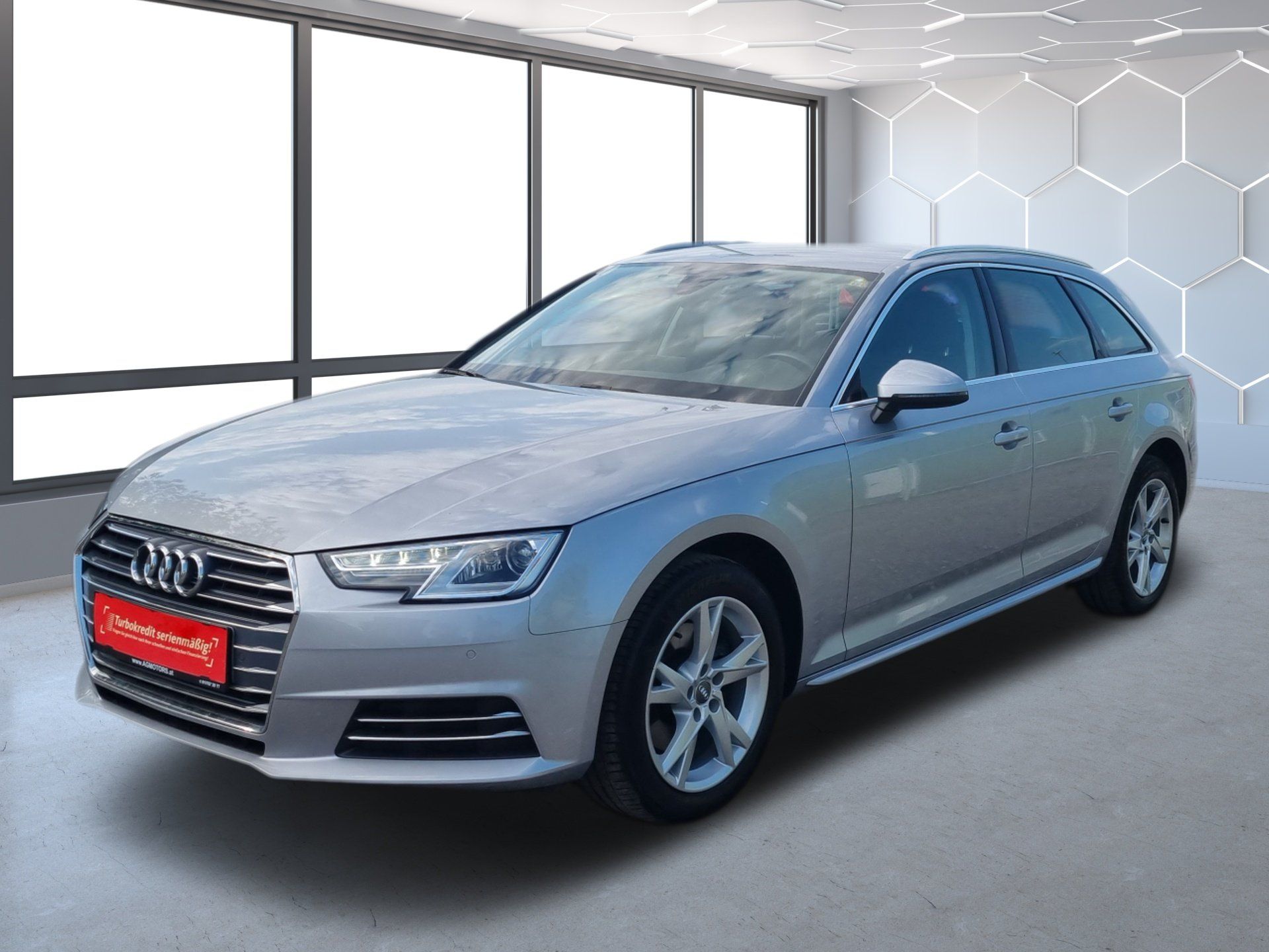 Strieborné kombi Audi vystavené v showroome, pohľad zľava spredu