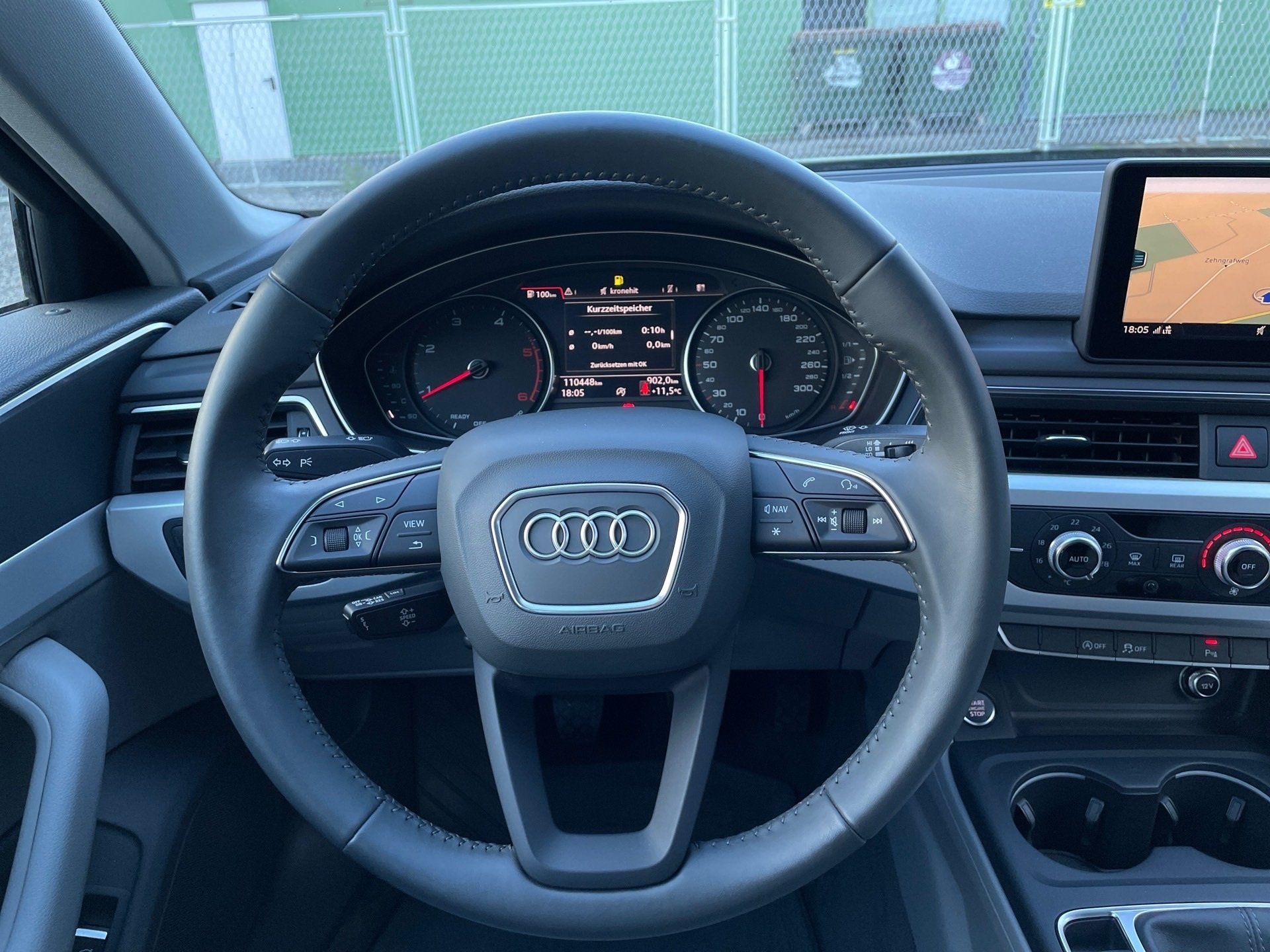 Audi driver’s seat view with steering wheel, digital dashboard, center console, and infotainment screen