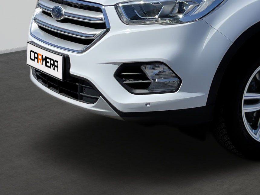 Front view of a white SUV with chrome grille and a black-and-white license plate on a road