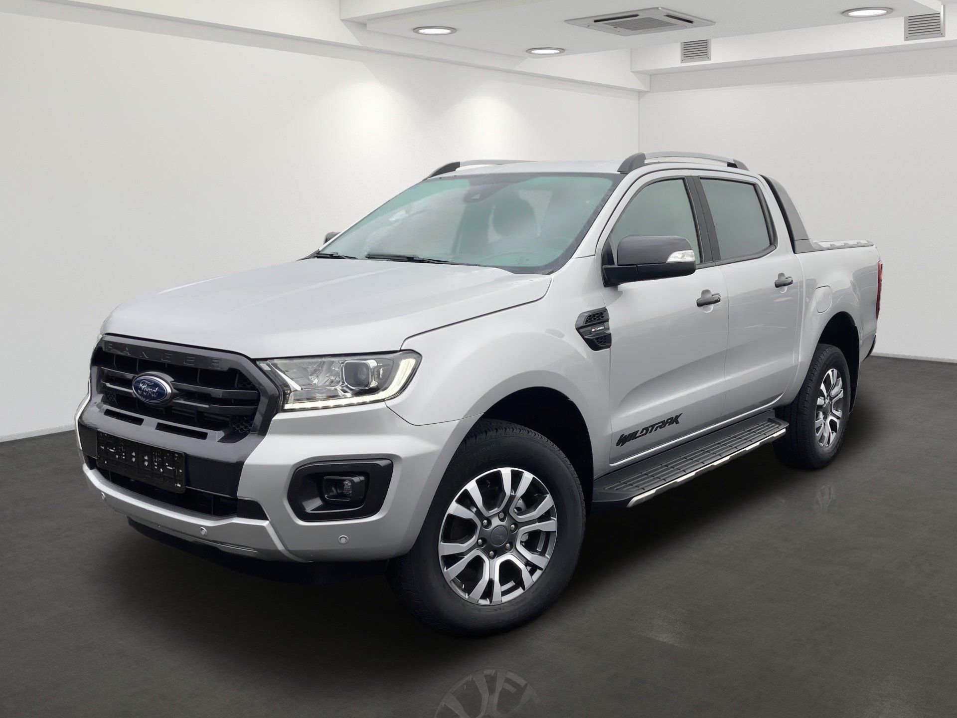 Strieborný pick-up Ford v štúdiovom showroome, pohľad zľava spredu.