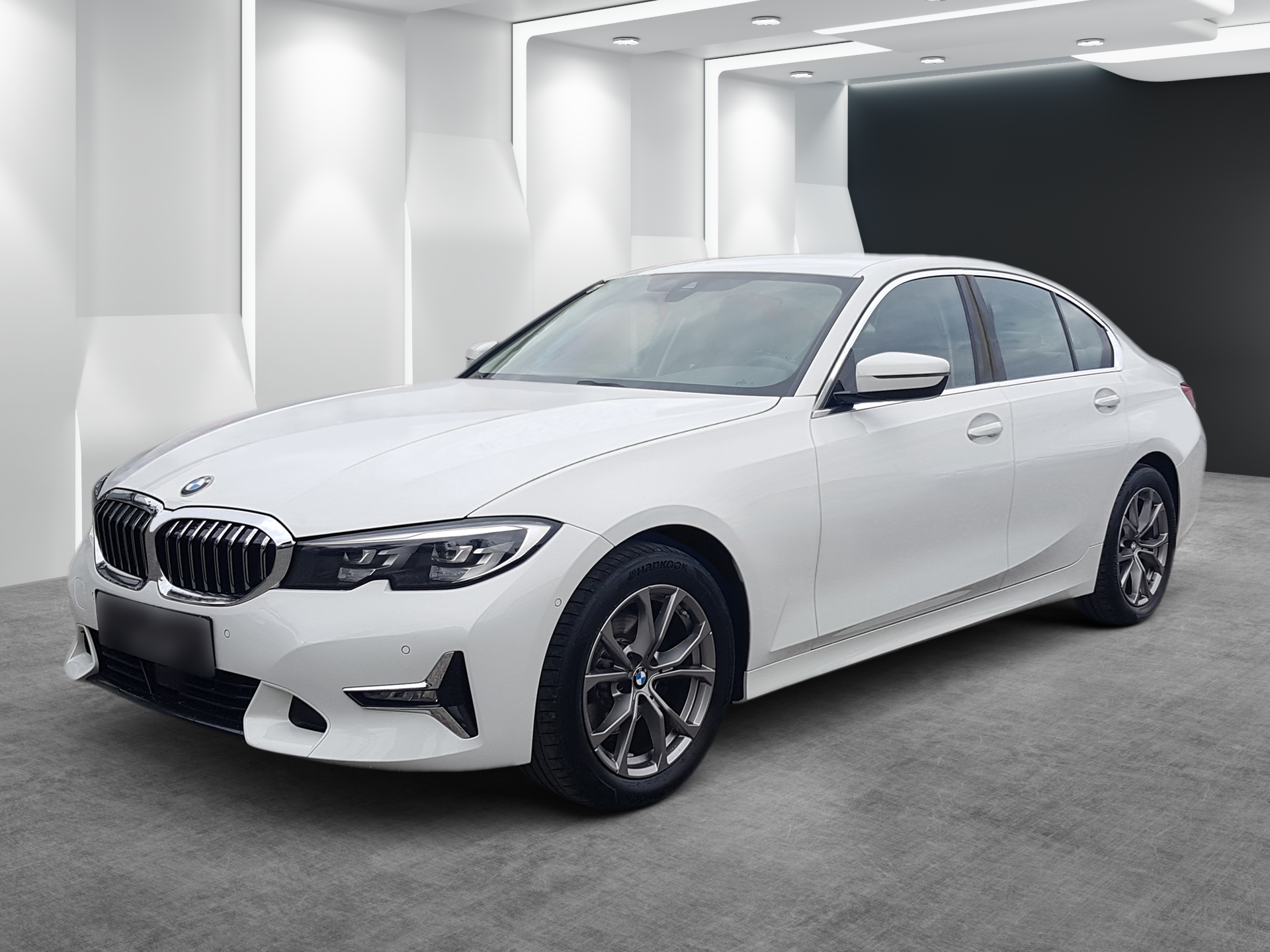 White BMW sedan parked in a bright showroom with a gray floor