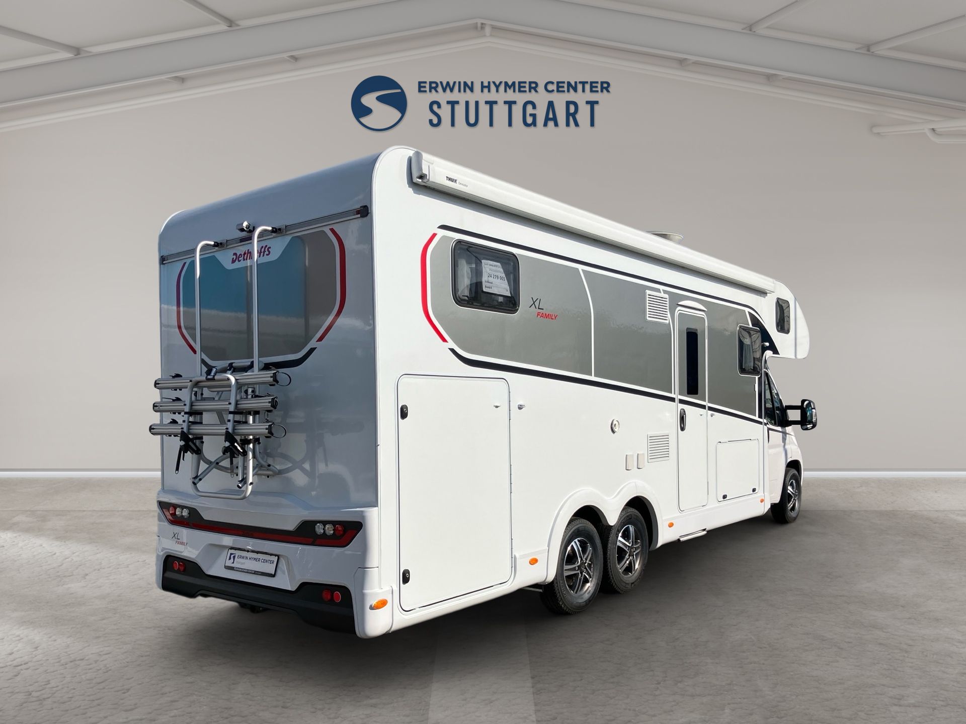 Biely luxusný obytný automobil v štúdiu, pohľad zozadu z troch štvrtín, s nápisom „Stuttgart“ na stene.