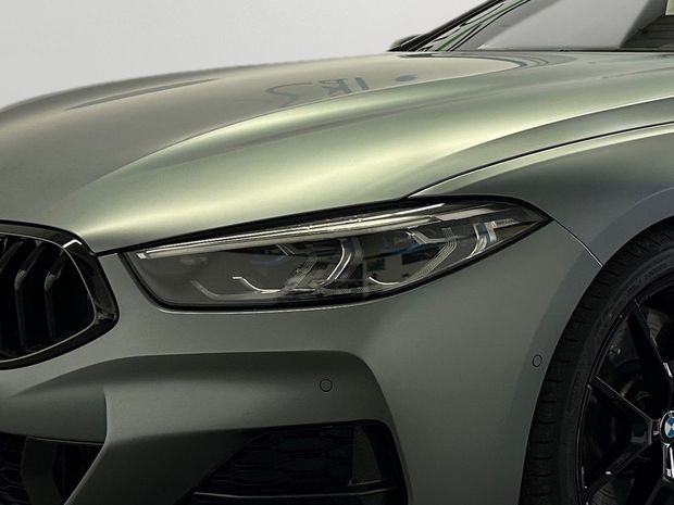 Eine Nahaufnahme eines BMW Autoscheinwerfers in einem digitalen Ausstellungsraum.