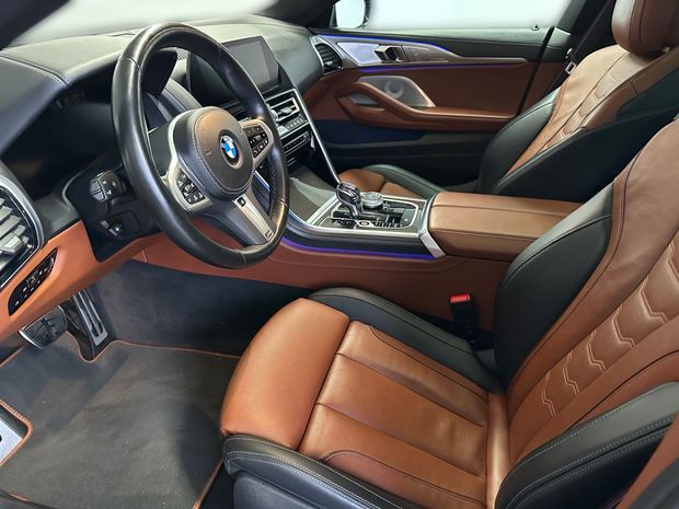 Der Innenraum eines BMW mit braunen Ledersitzen und einem Lenkrad