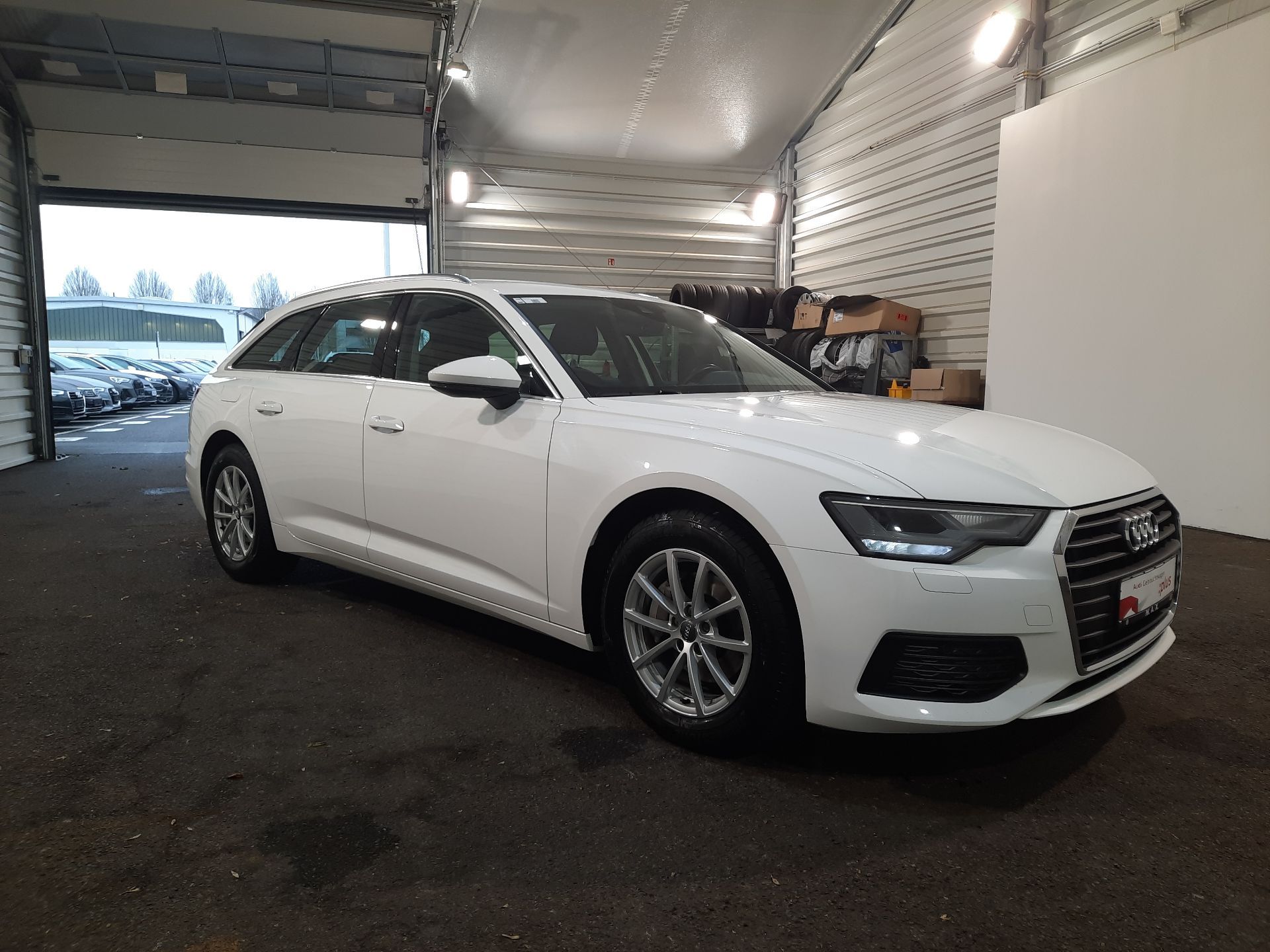 White Audi sedan parked inside a garage, front-right view