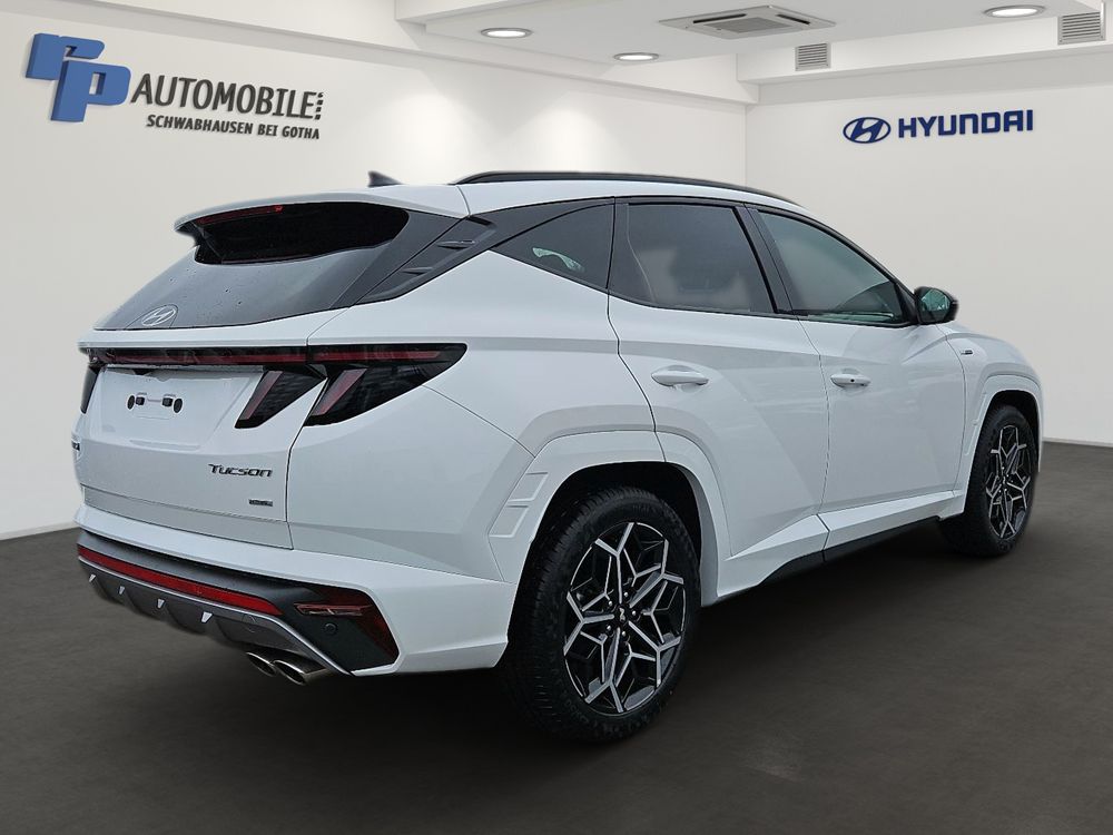Weißer Hyundai SUV, geparkt in einem Autohaus-Showroom, Dreiviertelansicht von hinten.